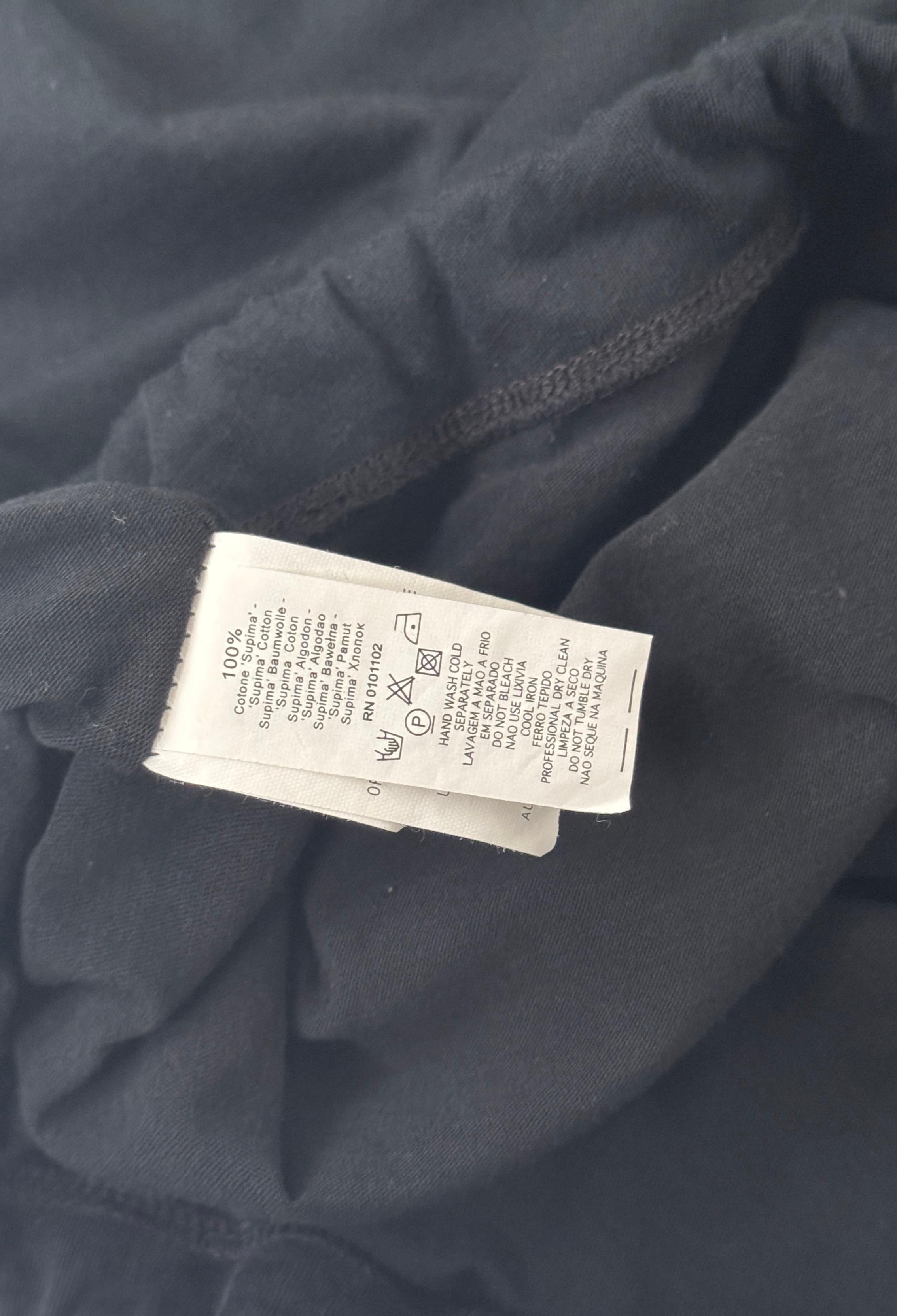 This black top by Stefanel embodies the casual-chic Italian style of the 90s and 2000s with a refined sewn-in layered design that combines an inner tank with a long-sleeve outer layer in a single versatile and comfortable piece made of soft stretch