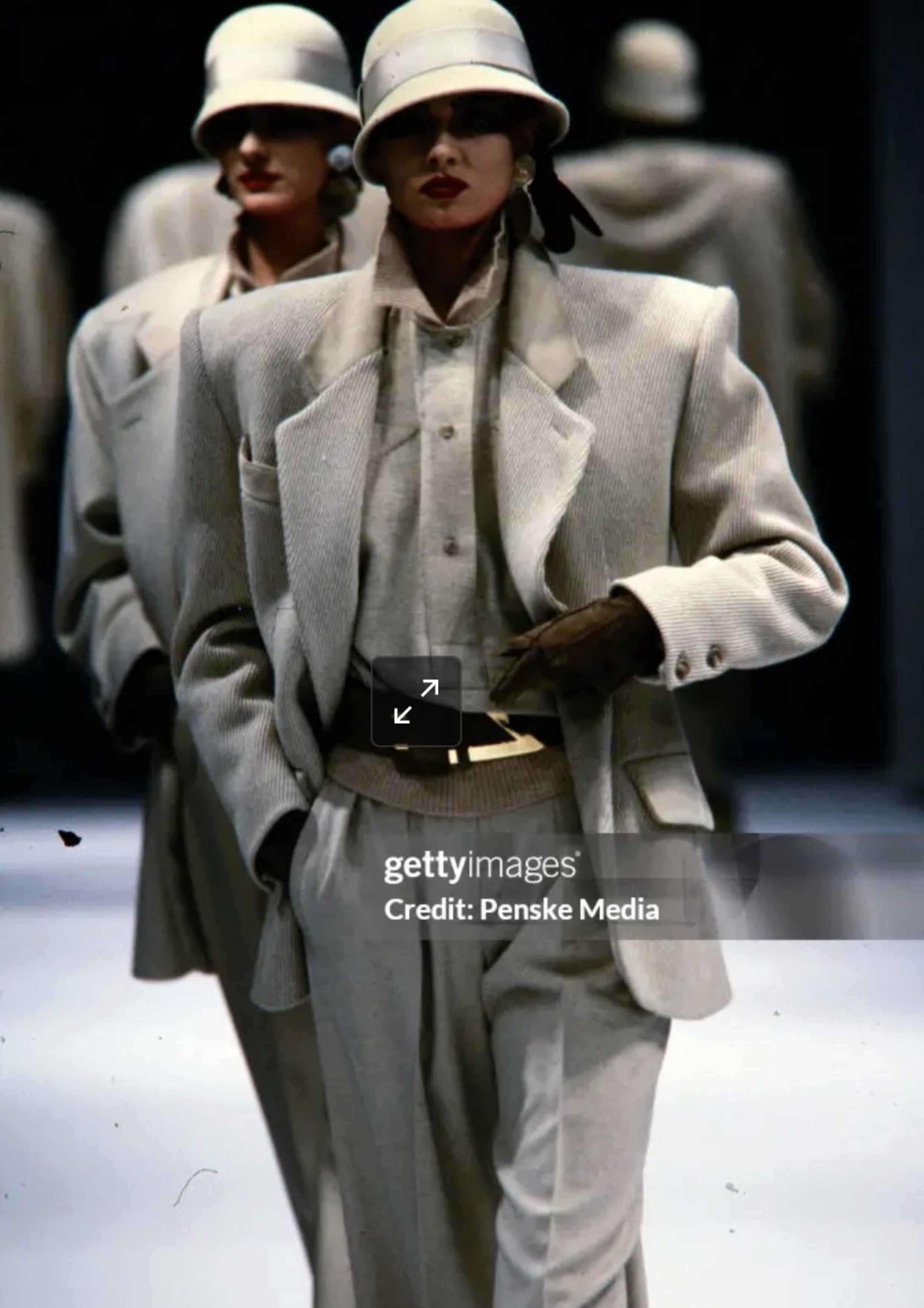 An extraordinary runway ensemble designed by Claude Montana for his acclaimed Fall/Winter 1984 collection. This museum-worthy set includes a structured wool coat with exaggerated shoulders and ribbed knit sleeves, a matching utility-style wool