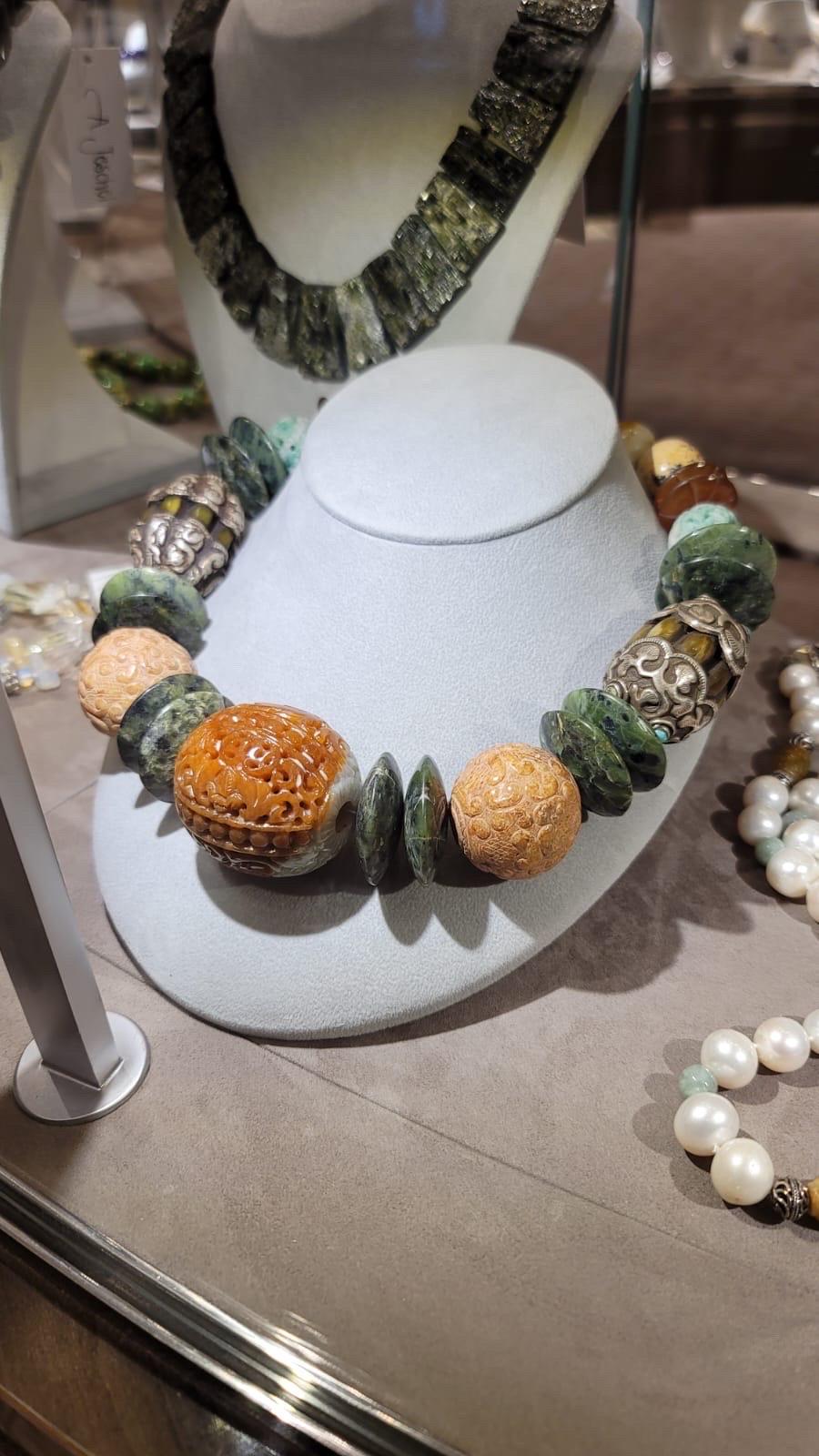 In this exquisite necklace, a harmonious composition of 27 distinct beads comes together, each possessing its own intriguing story. These beads blend seamlessly to create a stunning statement of complementary colors, captivating forms, and enticing