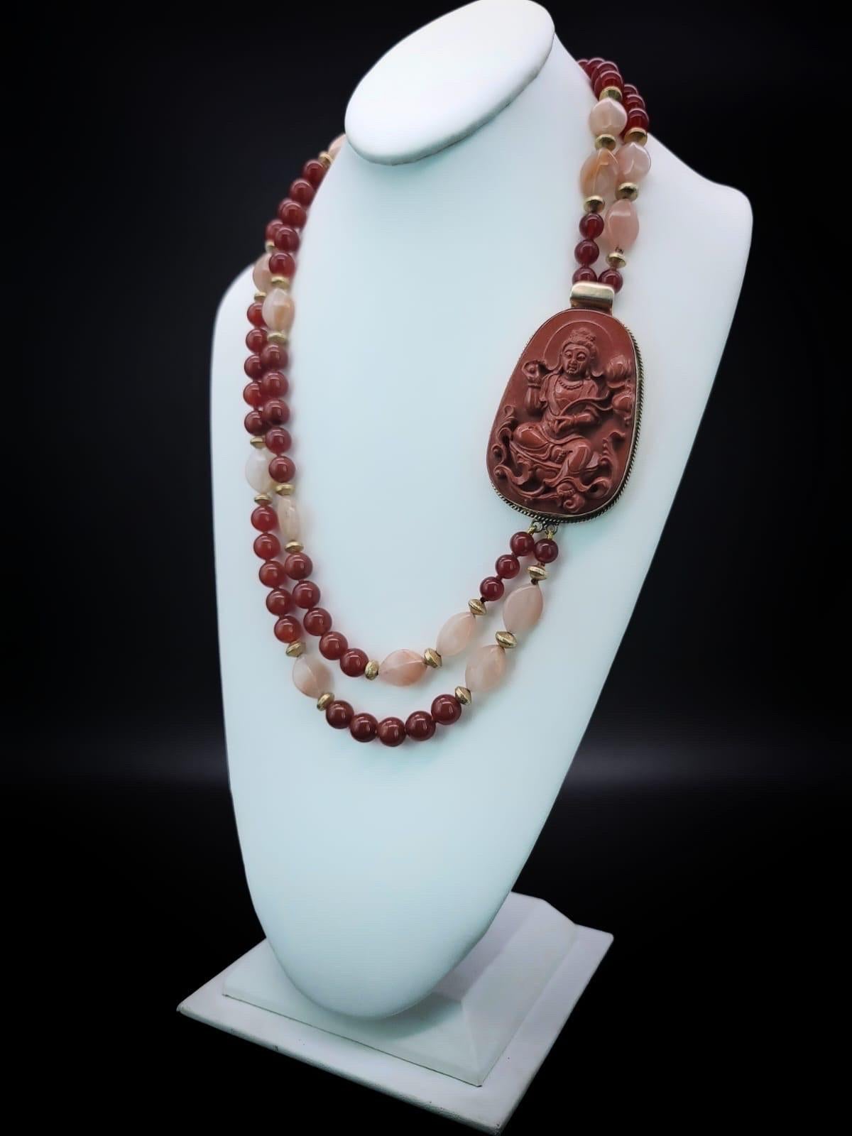 One-of-a-Kind

Carved Aventurine Buddha anchors Carnelian and Aventurine double strand matinee length necklace. 
A harmonious combination of rust-colored 10 m.m carnelian beads interspersed with creamy peach Aventurine. Accented with vermeil