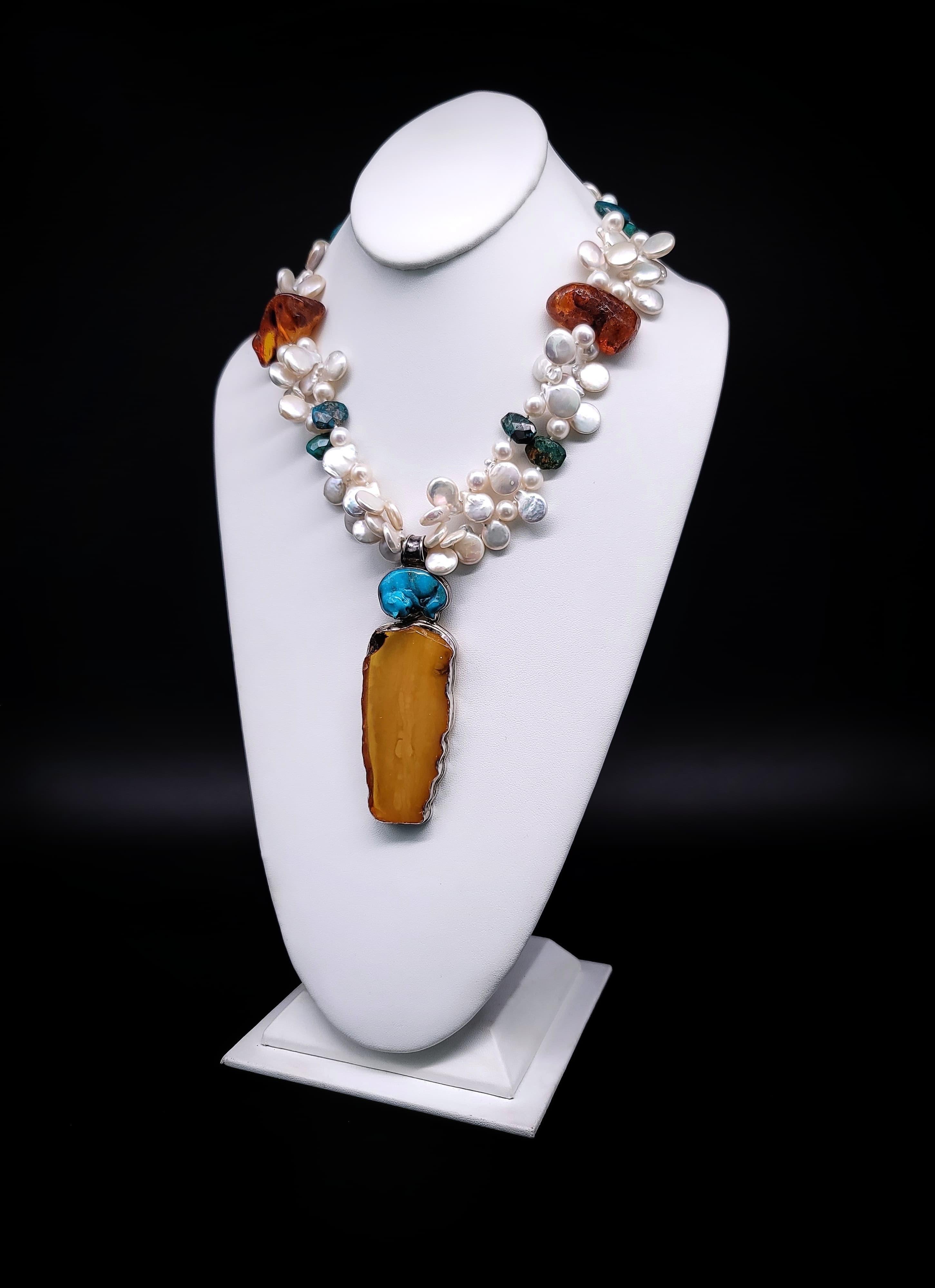 Embrace the allure of individuality with our meticulously crafted masterpiece – a dual-strand necklace showcasing the harmonious blend of lustrous Pearls, vibrant Turquoise, and captivating Amber. This necklace elegantly cradles a remarkable pendant