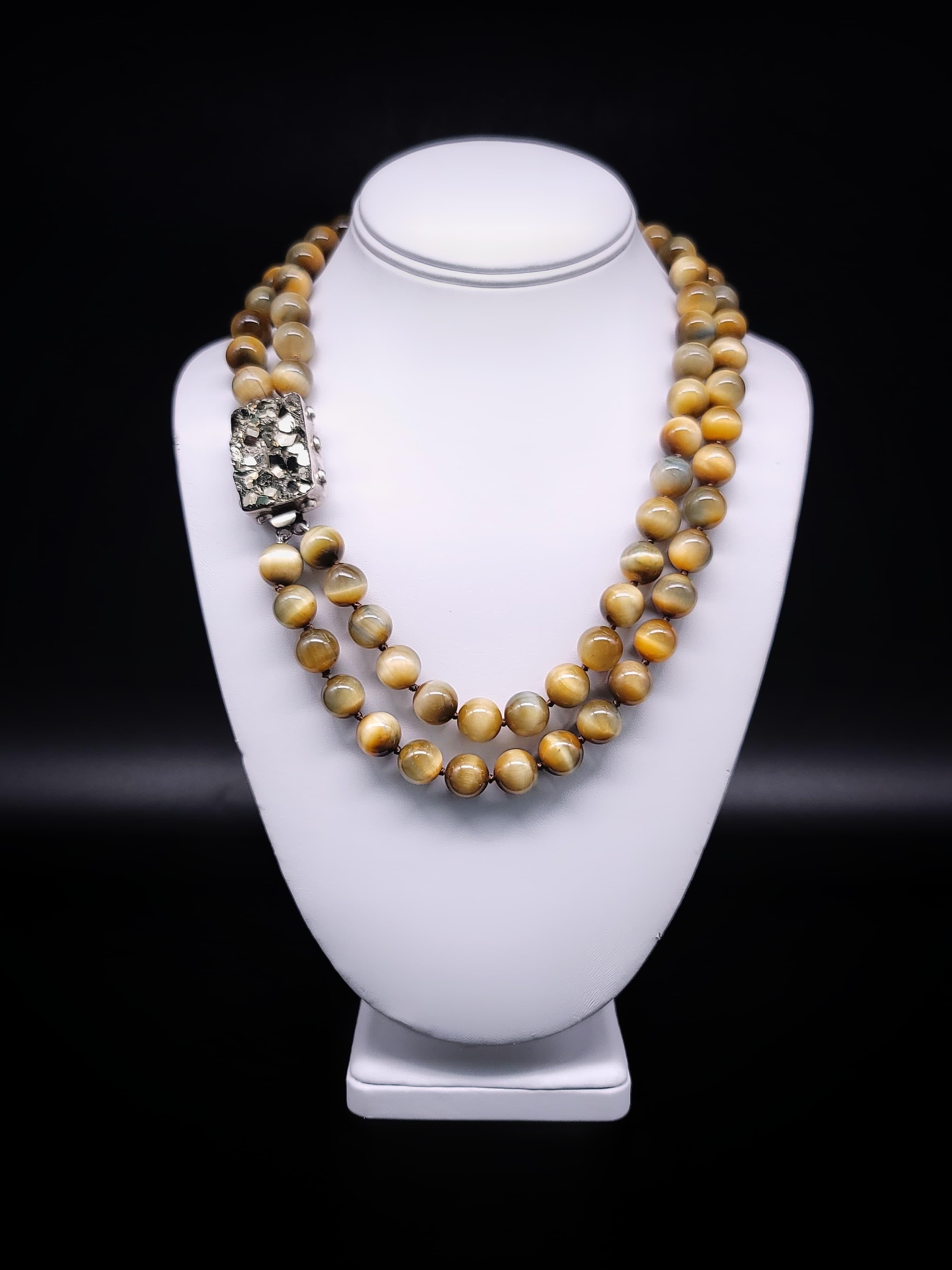 Indulge in the allure of the extraordinary with this captivating two-strand necklace featuring rare golden honey Tiger's eye beads, gracefully accented by a stunning Pyrite gemstone set in sterling silver. Pyrite, often dubbed 