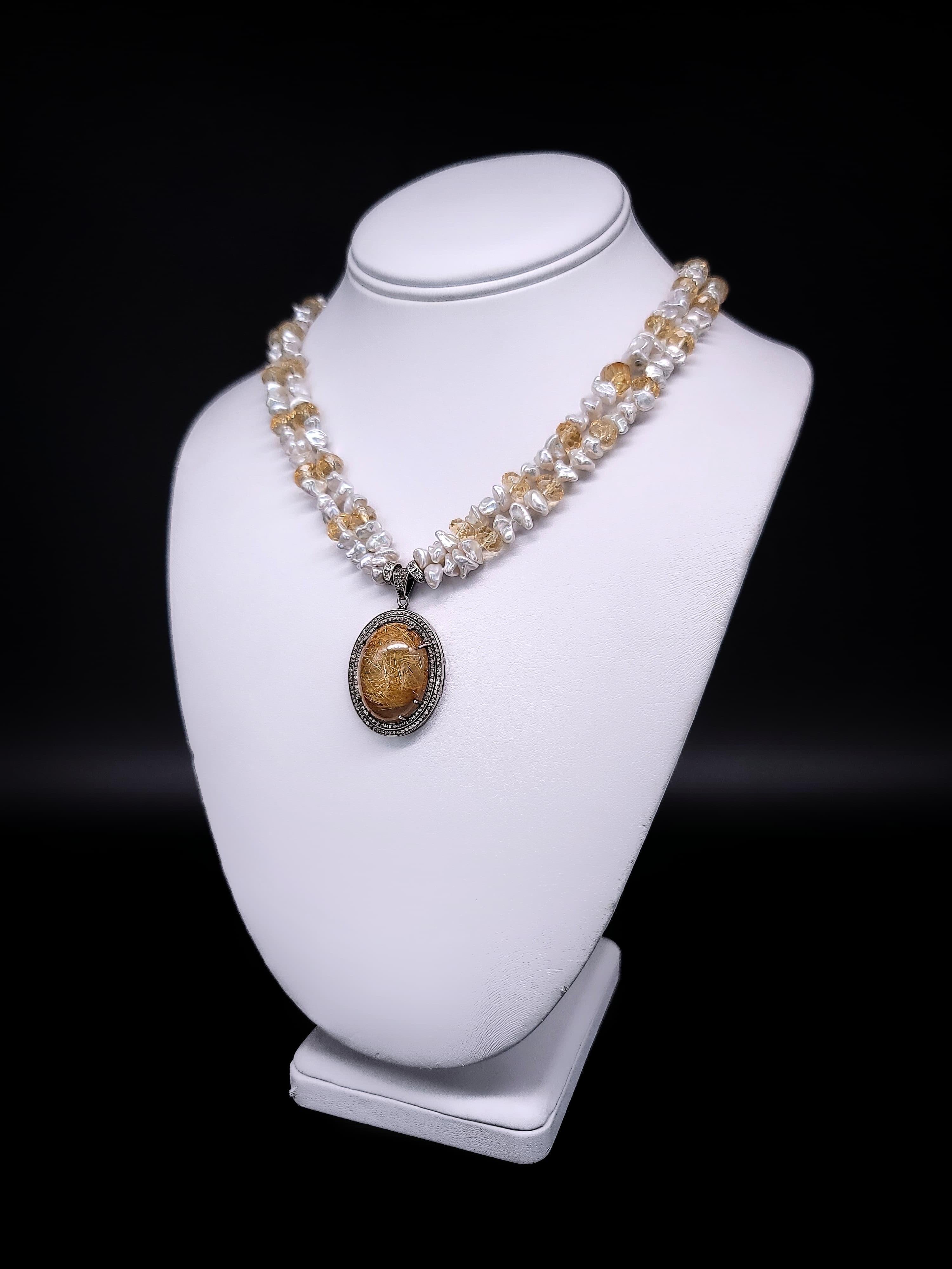 Diese einzigartige Halskette ist ein wahres Meisterwerk von Elaine Silverstein, das die natürliche Schönheit und Eleganz des Rutilquarzes zur Geltung bringt. Das Herzstück der Halskette ist ein großer, kuppelförmiger Rutilquarz, der perfekt von