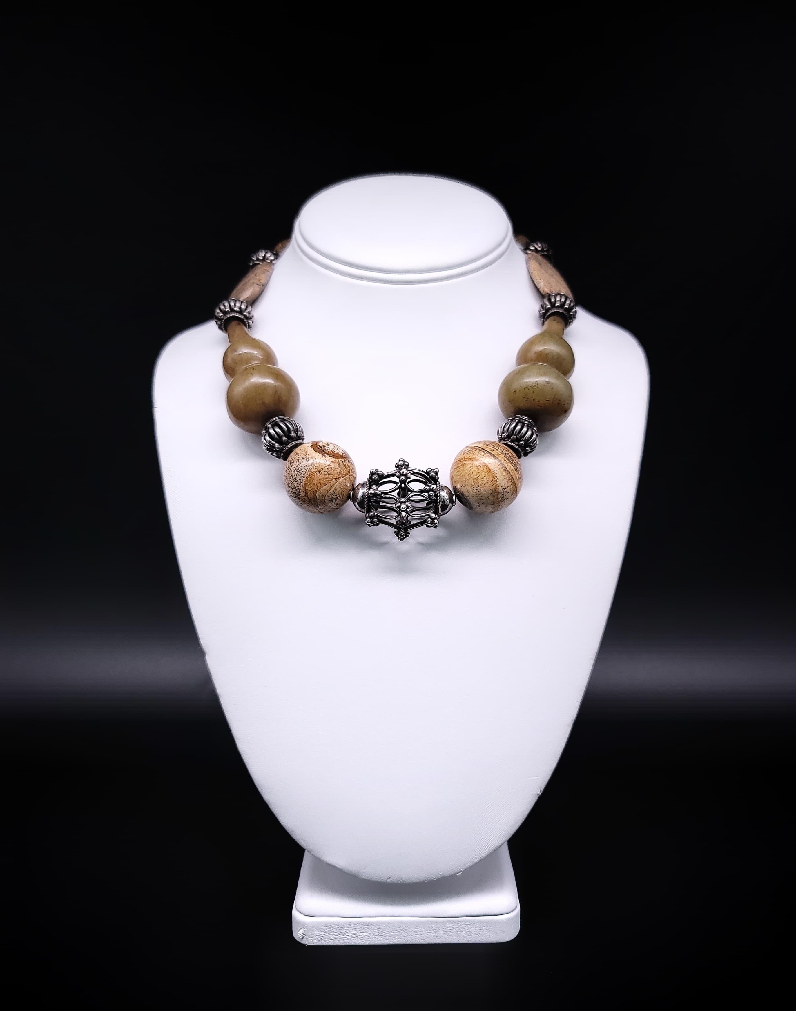 One-of-a-Kind

Add a touch of natural elegance to your everyday style with this stunning earth-toned necklace. The understated design features Sou Chou Jade in a familiar vase pattern, complemented by picture Jasper flat beads and balls, as well as