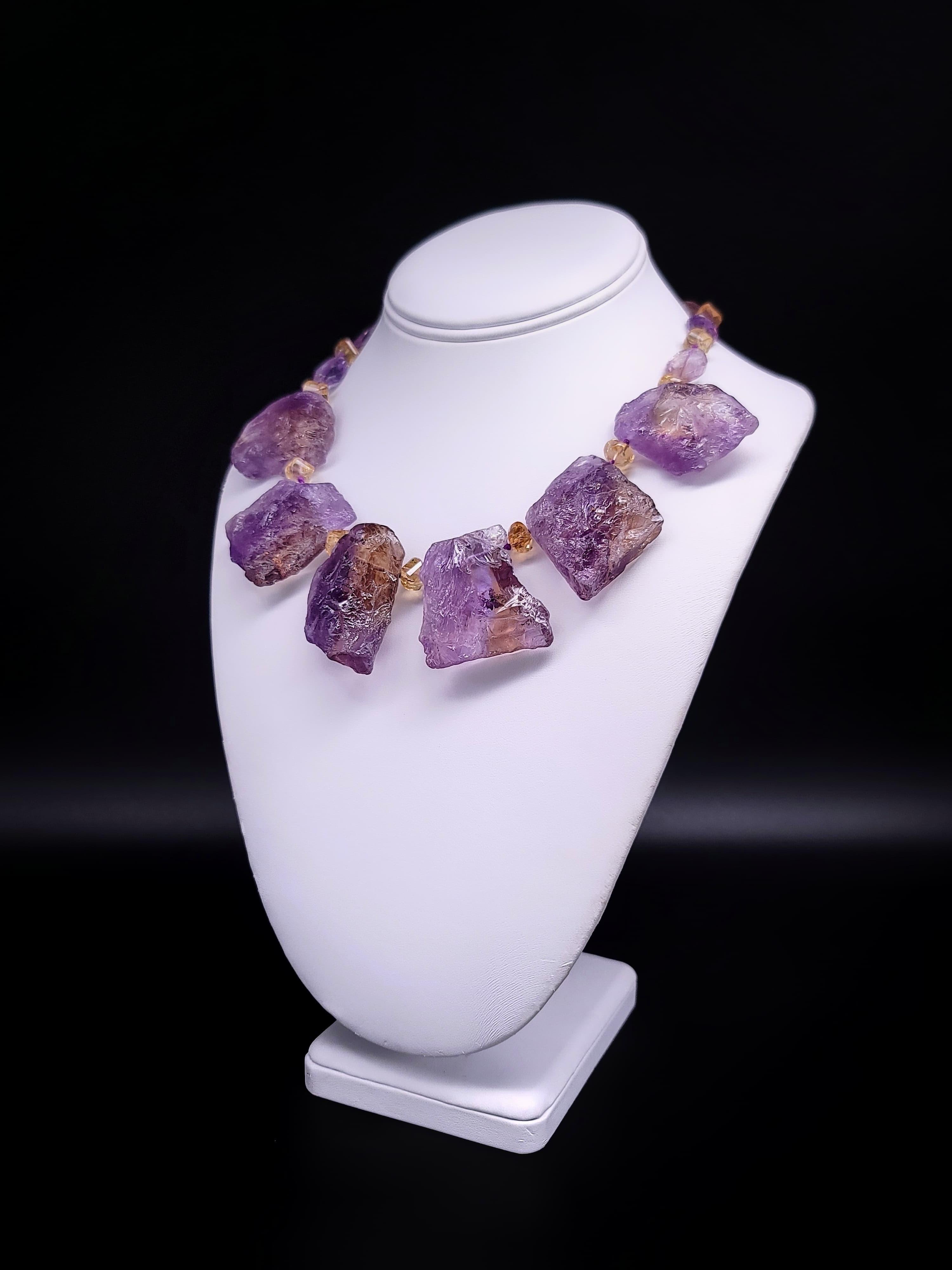 One-of-a-Kind

Large Ametrine specimen plates. Dramatic hammered ametrine ( a mixture of amethyst and citrine) in beautiful translucence stones hammered on the front side, and polished on the back. It is suspended from a necklace of facetted