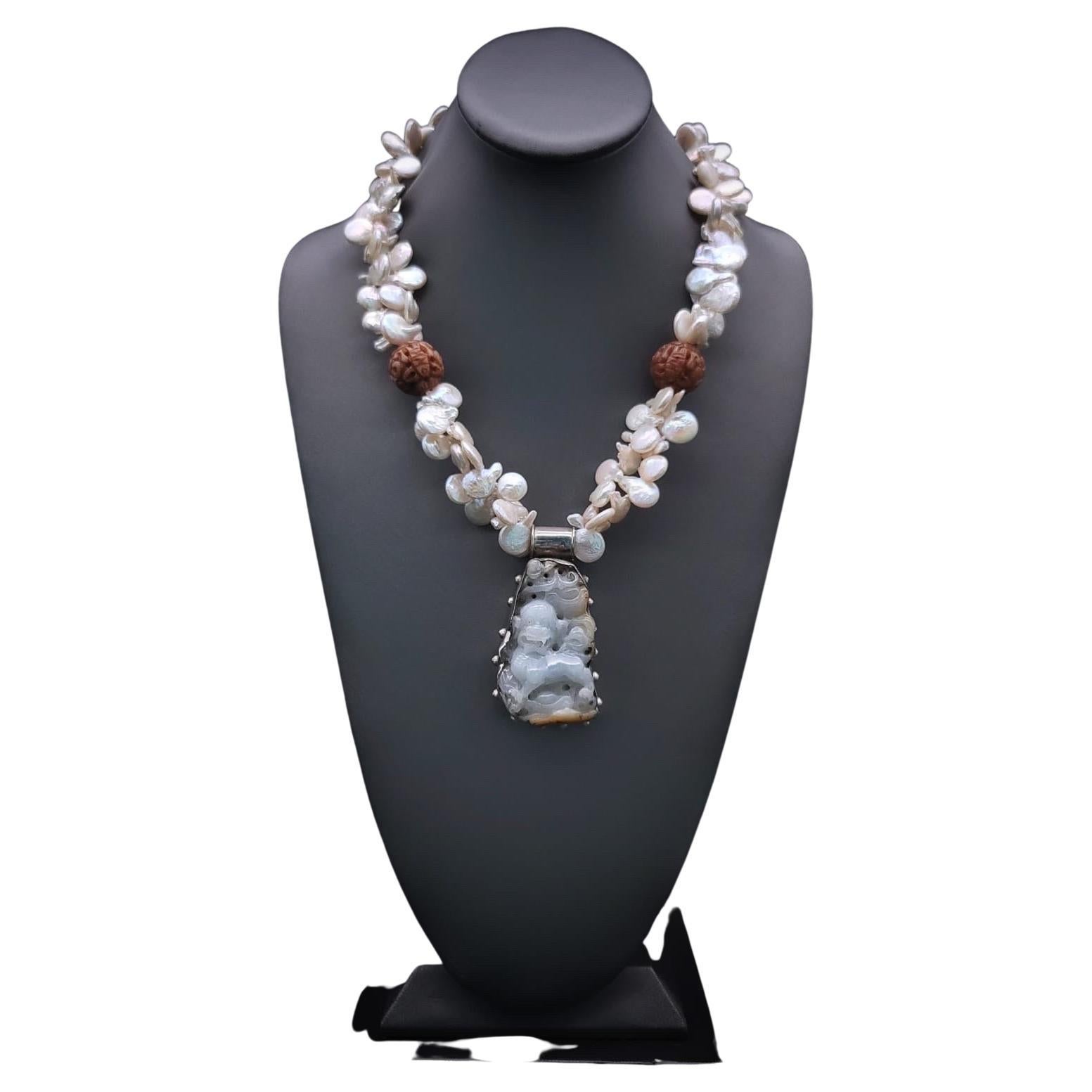 One-of-a-Kind

The foo dog pendant hangs from a Baroque Pearl double strand with a pair of carved tobacco balls and coin pearl. The familiar imperial  Foo dog Chinese architectural ornamental lions are usually placed at the entrance of a building to