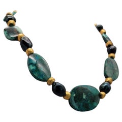 Collier Chrysocolla de A.Jeschel séparé par des perles baroques en forme de paon vert.