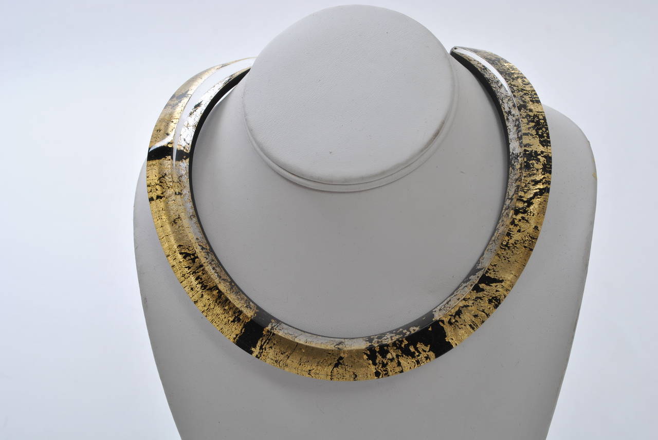 Dramatic lucite collar contoured to the neck. Composed of a thick layer of clear atop a narrow layer of black lucite flecked with gold. Slips on the neck. Contemporary piece by Paris artisan.
