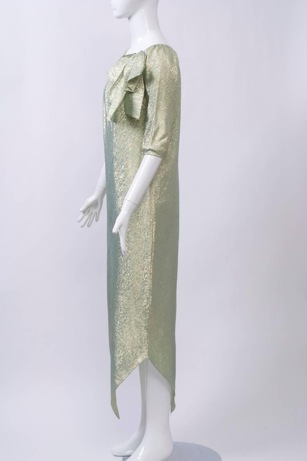 Robe longue facile à porter, avec un ourlet en mouchoir de poche, des manches 3/4 et un col rond froncé terminé par un gros nœud. Fabriqué à partir d'un synthétique léger en aqua et or. Pas d'étiquette, mais attribué à Halston.
