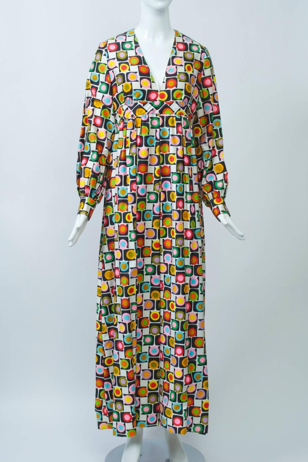 Palazzo jumpsuit in a graphic and colorful geometric print executed in polished cotton. Styling features a v neck and set-in empire band, long full sleeves with tight wristbands and a full divided skirt concealing the pants legs. Back zipper, fully