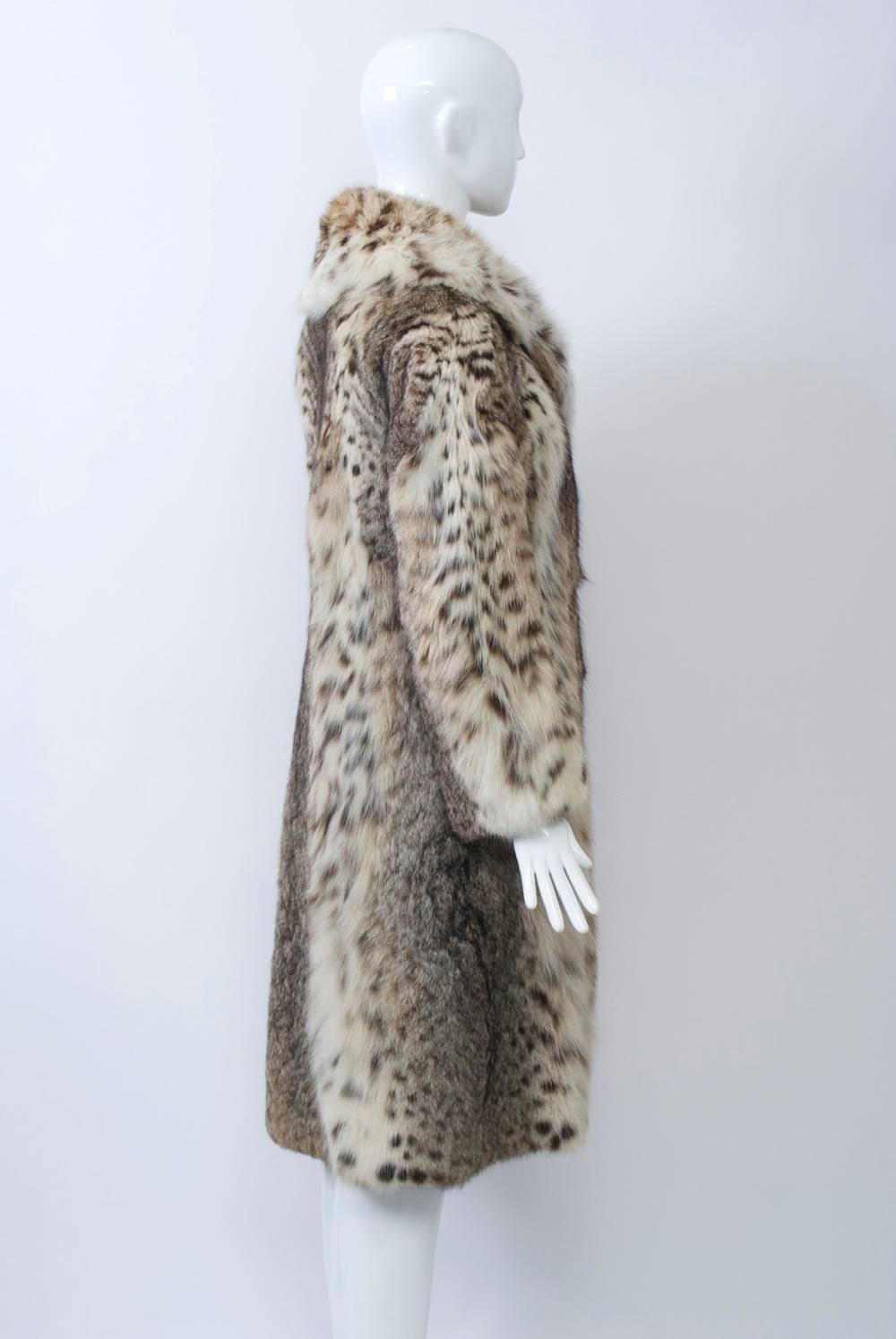 Lynx coat from the late 1960s-early 1970s that features a nicely shaped profile with double-breasted effect and a large notched collar. A fluffy fur, but with a slim fit; below-the-knee length. Fur is supple and soft, lining excellent. Approximate