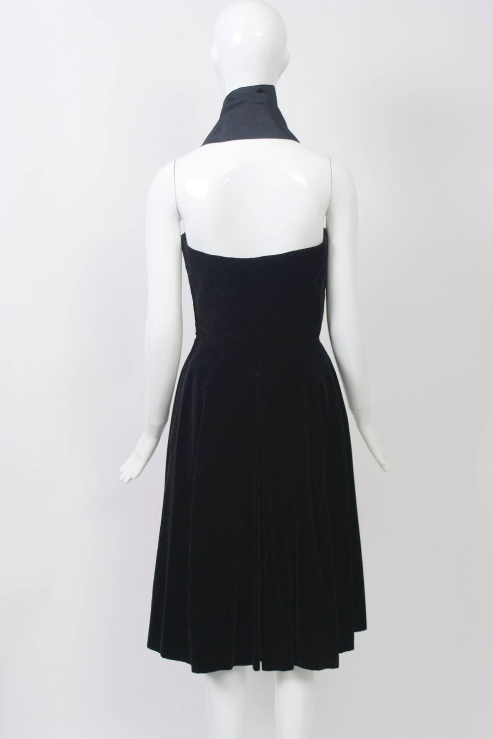 J. Suzanne Talbot was a celebrated designer during the 1920s and onward in France, known particularly for her hat designs. This dress from the 1950s, bearing her label, shows the hallmarks of couture. Crafted of black velvet, the dress features a