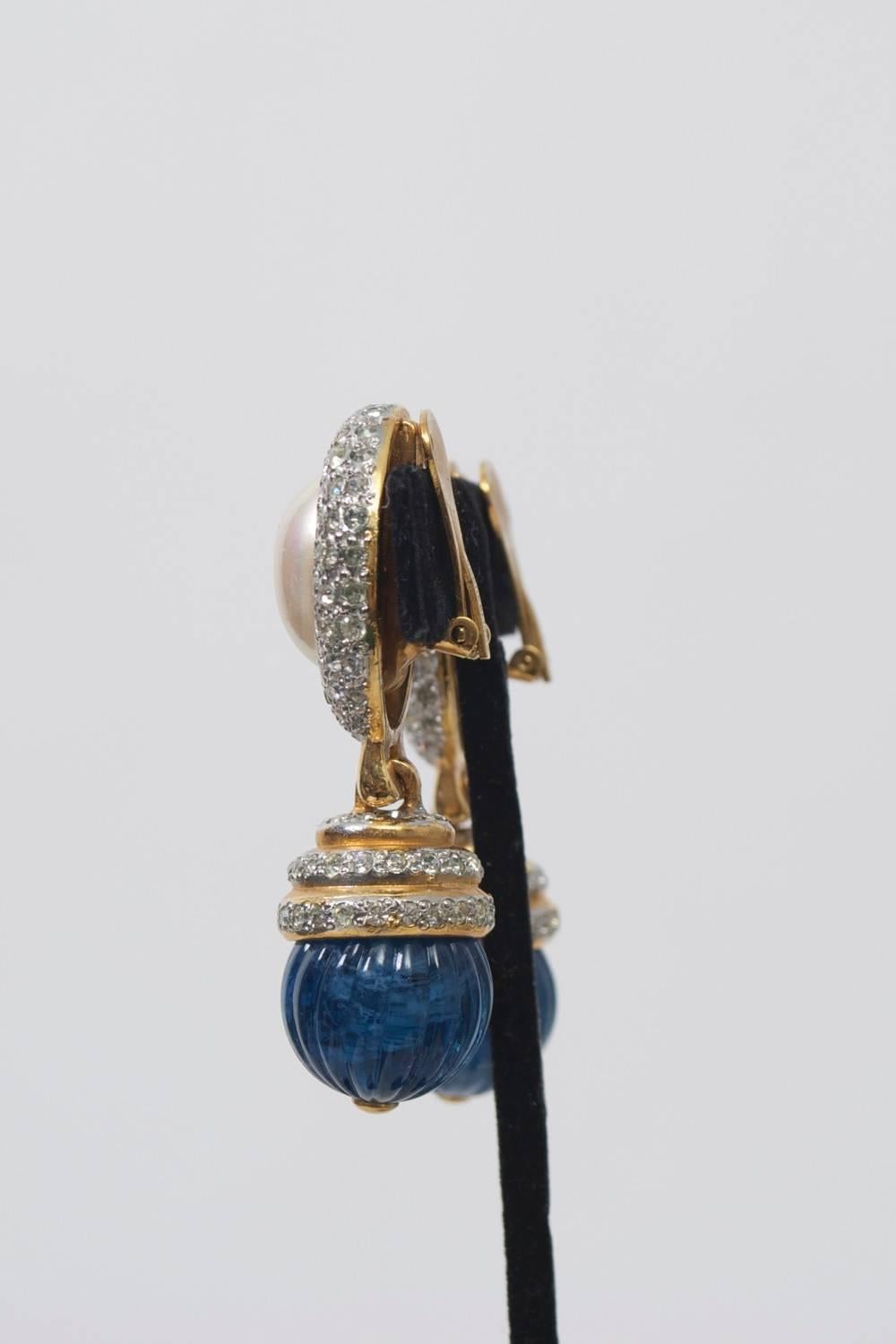 Vogue Bijoux drop earrings, the oval earpiece of a central mabe pearl framed by rhinestones suspending a ribbed, round blue stone topped by graduated rings of gold and rhinestone. 