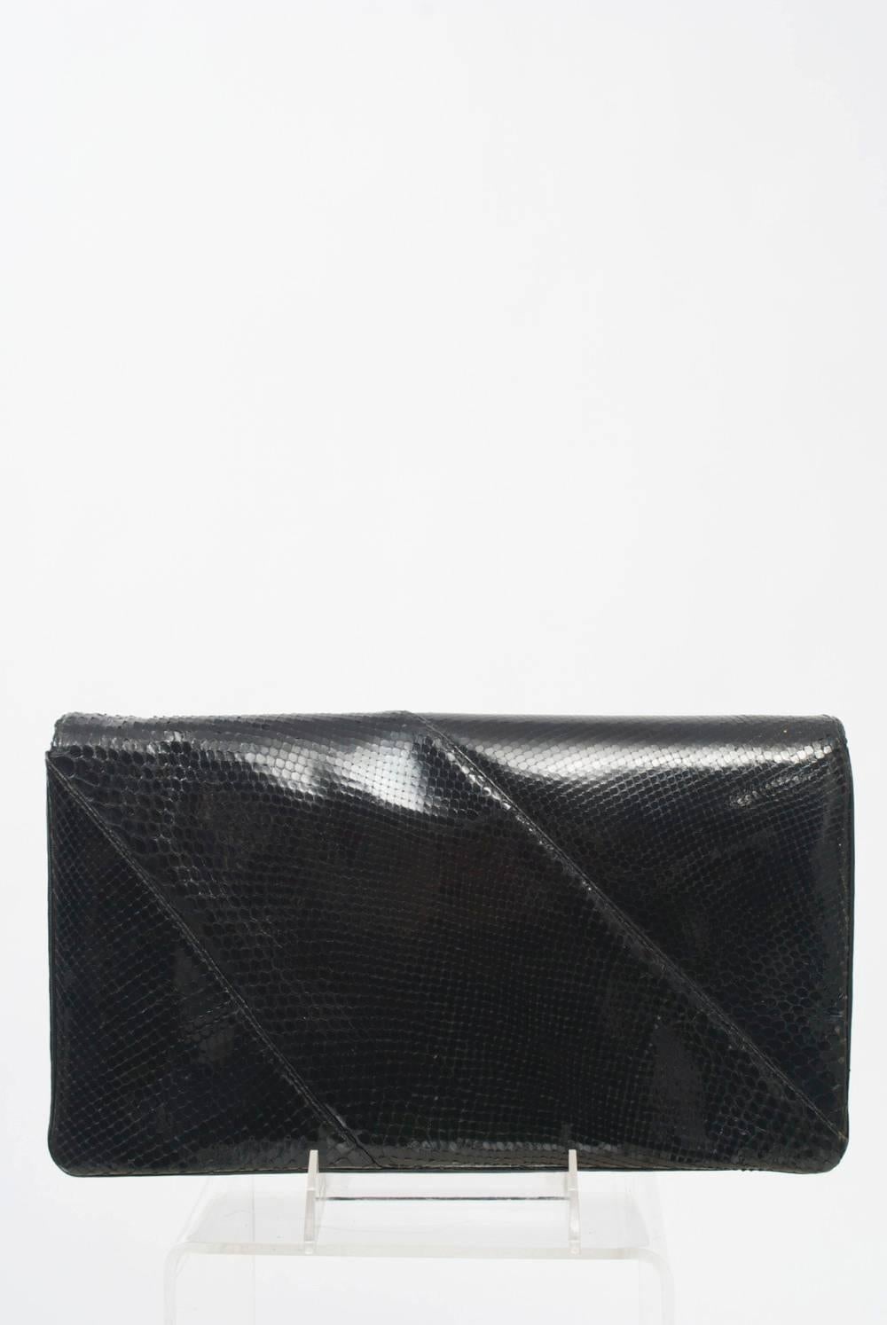 Nice size black snake clutch with silver metal trim featuring diagonally pieced skins and multiple interior compartments.
