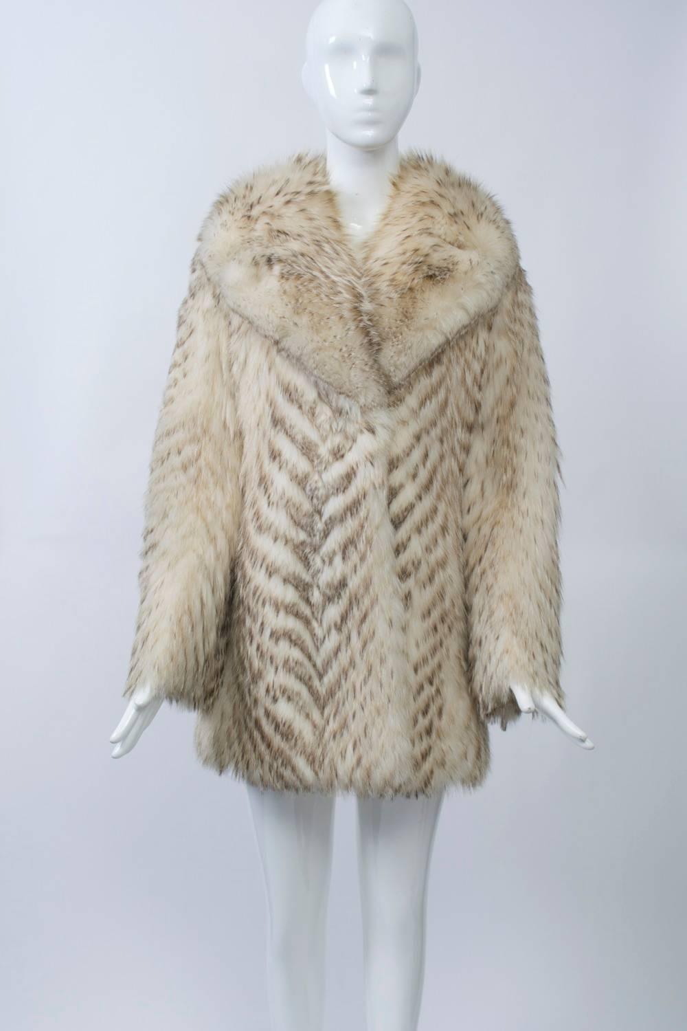 Long-haired creamy fur with light brown chevron markings and wide, notched collar. A fun fur, badger is warm and luxurious, as well as extremely durable; it was quite popular during the 1970s and '80s. Made by high-end furriers Christie Bros.