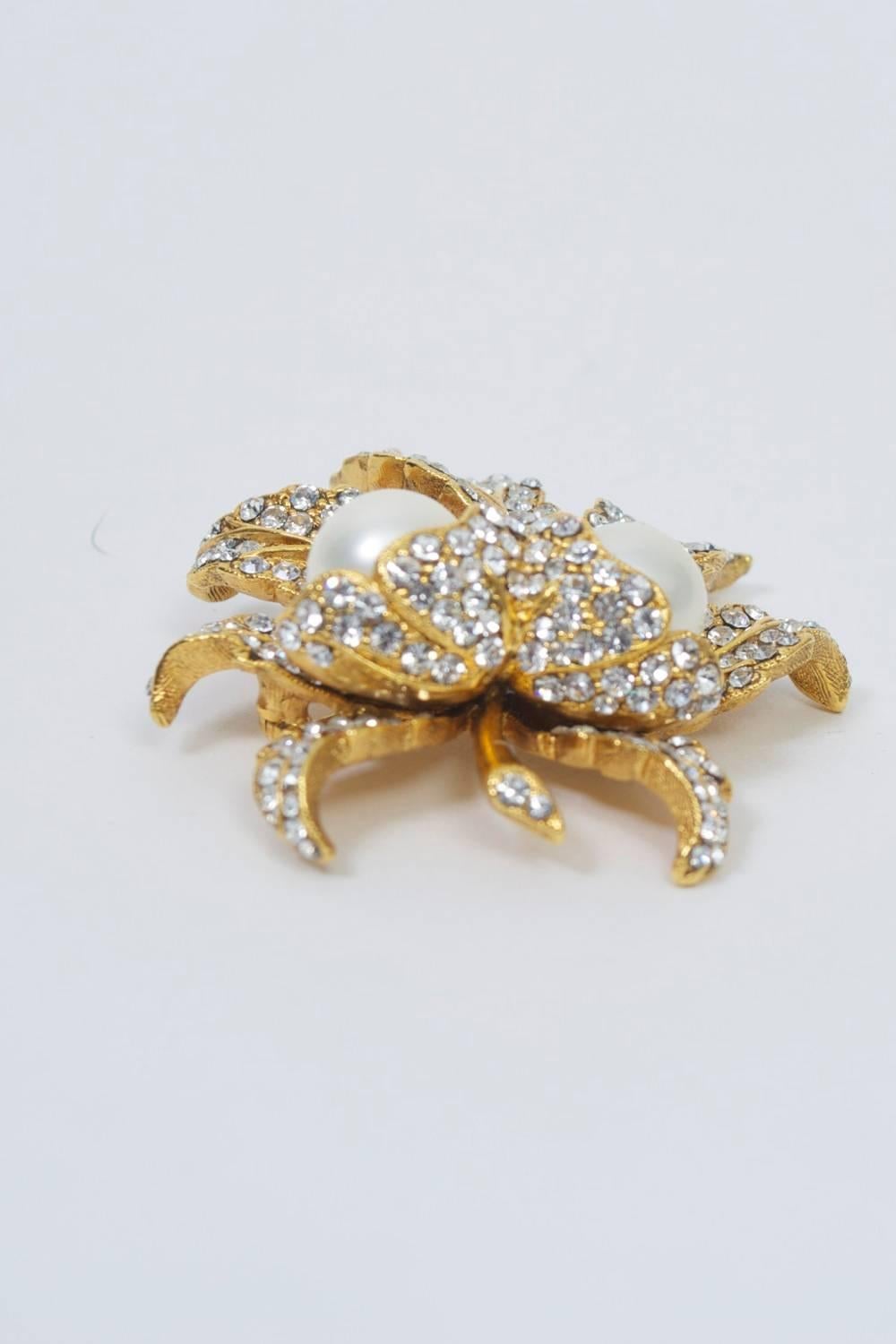 Leaf brooch in textured gold, each leaf set with rhinestones and with two large pearls at center.