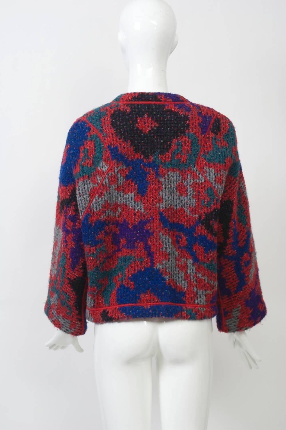 Missoni jacket in predominantly red/blue print with red stitched borders and red plastic amoebic-shaped buttons. Thick knit, unlined, with round collar and patch pockets. Alpaca/wool/mohair blend.