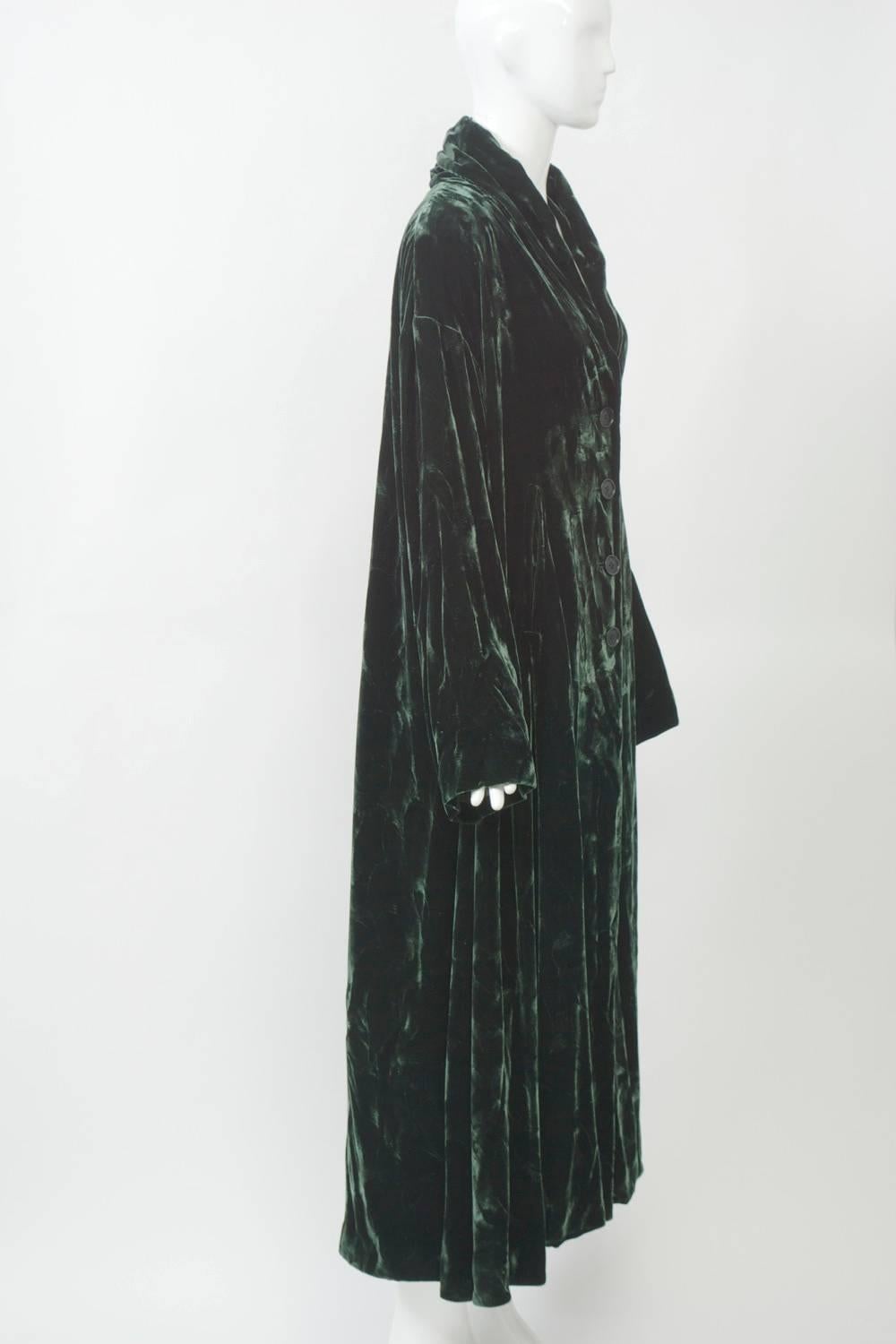 Romeo Gigli mid-calf length coat in crushed dark green velvet. Simple, oversized cut with dropped shoulders, small shawl collar and single-breasted closure with four buttons. Deep vent in back. 