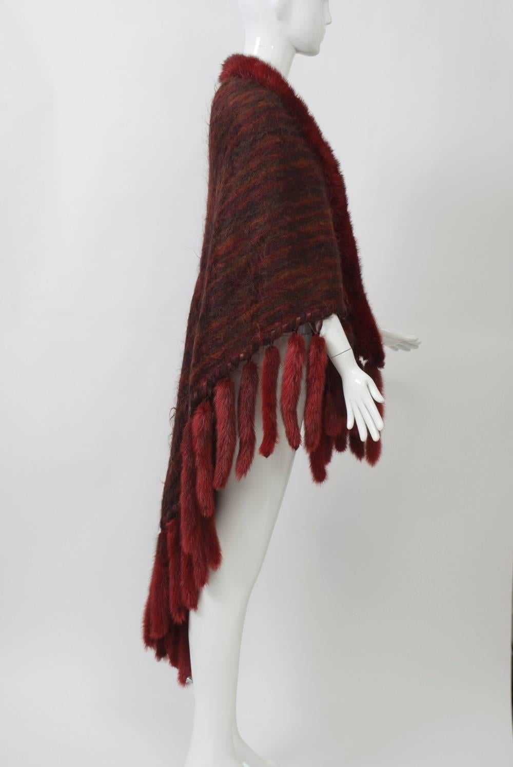 Deep shawl in striated orange/brown mohair trimmed with dyed matching mink around collar and mink tails around hem, which is whipstitched in brown leather.