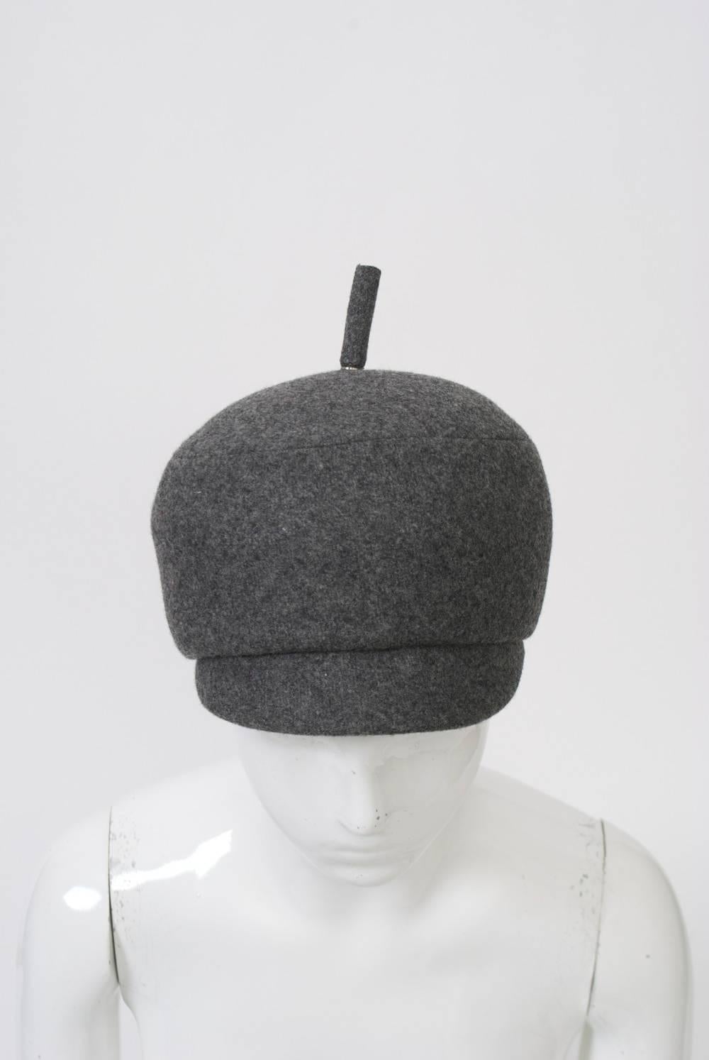 1960s gray flannel gogo hat with cap-type brim and raised round crown with cylindrical accent on top. lined in black taffeta.