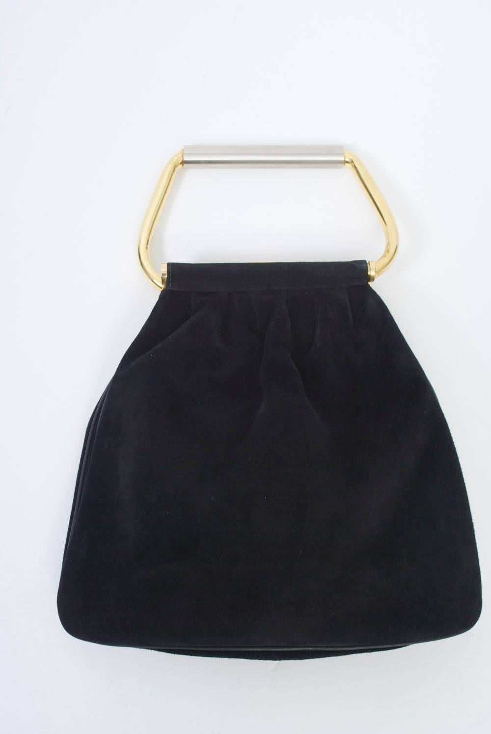 Cesare Piccini soft black suede bag featuring a loop handle out of tubular metal,  each side connected to the opposing end of the bag and through the top suede channel. The curved gold metal loop is overlaid across the straight top with matte silver