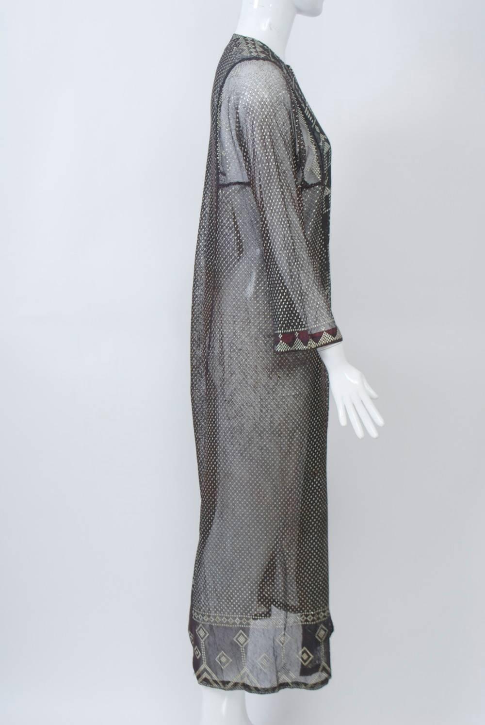 Caftan-style dress in black Assuit fabric, mesh woven with silver metal, that originated in Egypt and popularized after the Egyptomania following the opening of King Tut's tomb in 1922. Simple woven pattern throughout punctuated by geometric motifs