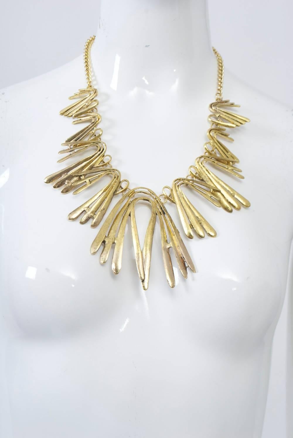 Gold tone necklace composed of boomerang-shaped components in graduated sizes is attributed to Oscar de la Renta, but unmarked. Chain in back is adjustable. Great statement necklace. Central element measure 3.5