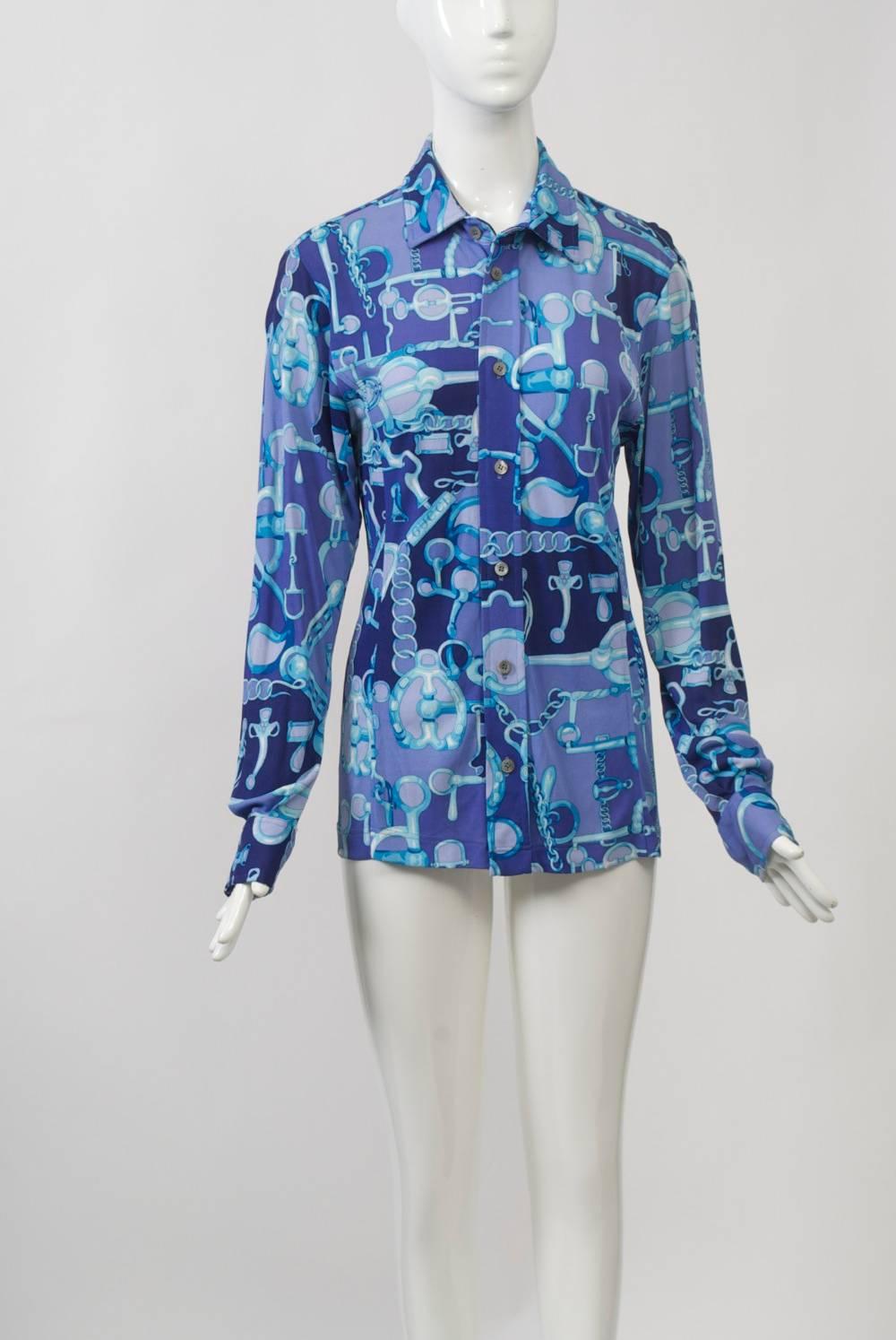 Gucci button-front shirt in varying shades of purple print with a horse-related theme. Fabric is a rayon/nylon blend. Front placket with gray pearl buttons, which also adorn the wrists. Long, shaped bodice.