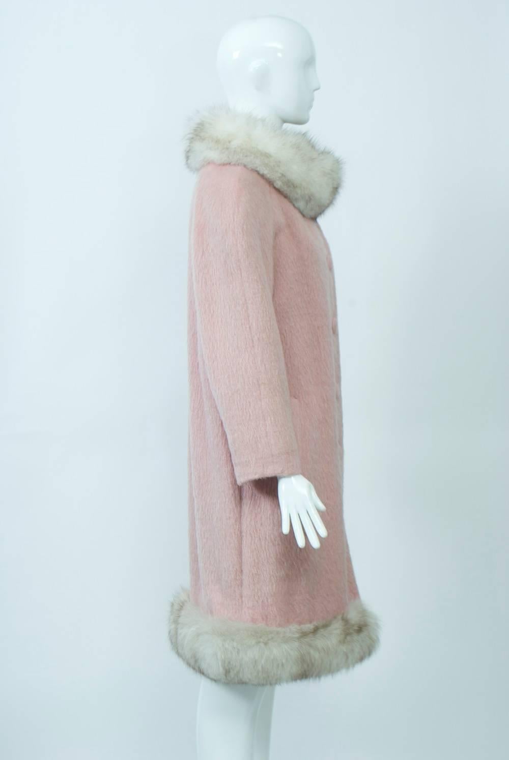 Lilli Ann's coats and suits, all made from beautiful imported fabrics and many trimmed with fur, are highly collectible. This coat is exemplary, made from pink mohair and trimmed with gray fox around the ring collar and hem. Straight profile with