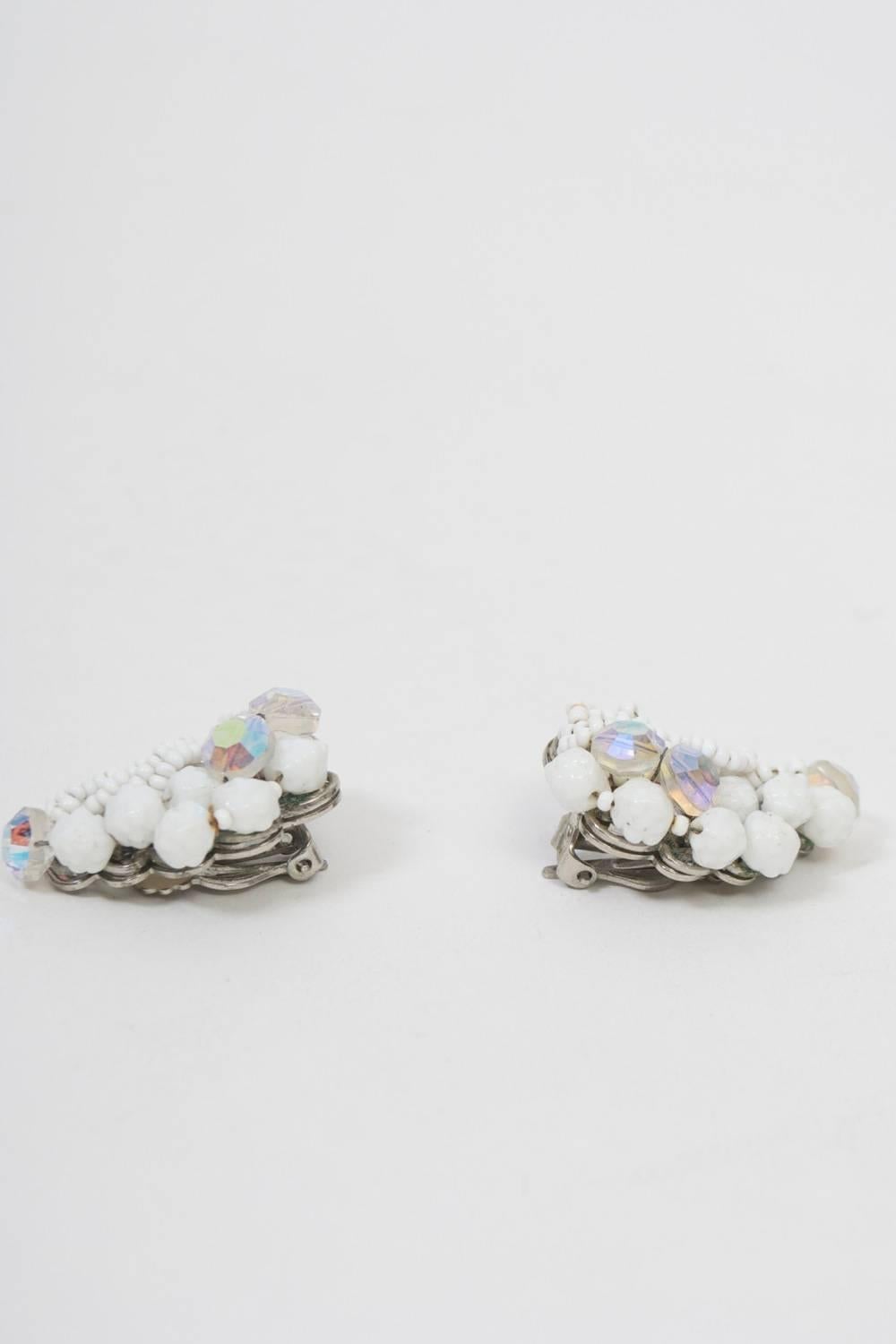 Crescent-shaped clip-on earrings by Robert, much of whose work resembled that of Miriam Haskell. These are composed primarily  of white beads, some diminutive and smooth, the others larger and faceted. Each earring is further embellished with ABA