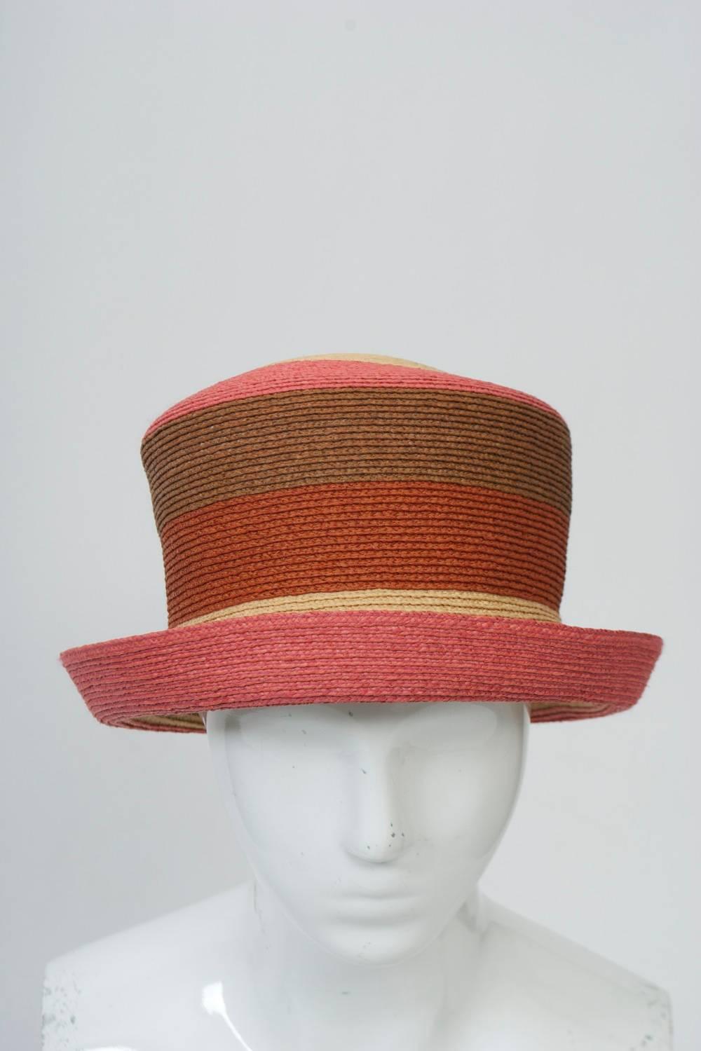 Australian designer Annabel Ingall hat in bands of natural, melon, rust, and brown straw. High crown with small, turned-up brim. Looks unused.