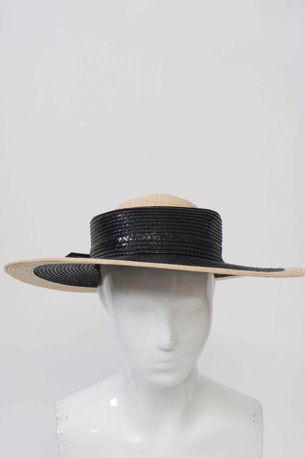 Striking straw hat by Mr. John with wide brim, the crown and outer brim in natural straw, the rest in black, including a 