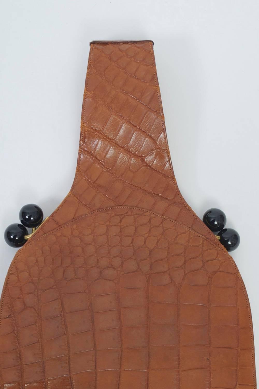 Another great find from Koret, which produced some of the best bags in mid-century America. This example is in tobacco-toned crocodile and has a slim profile, the body tapering to a continuous wrist hold at top. The bag features kiss closures on