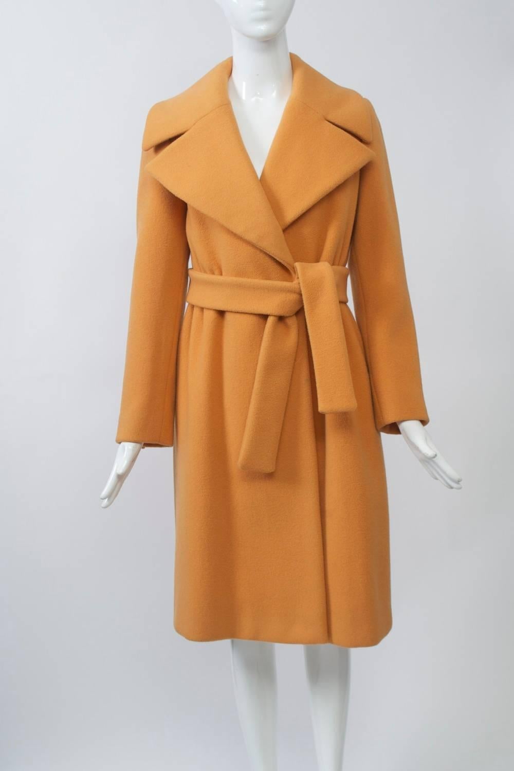 From John Anthony, whose luxurious, simply-constructed creations were among the best starting in the 1970s, this unusual and rich color of pumpkin melton wool, wrap-style coat features a wide notched collar and self tie belt. The waist is