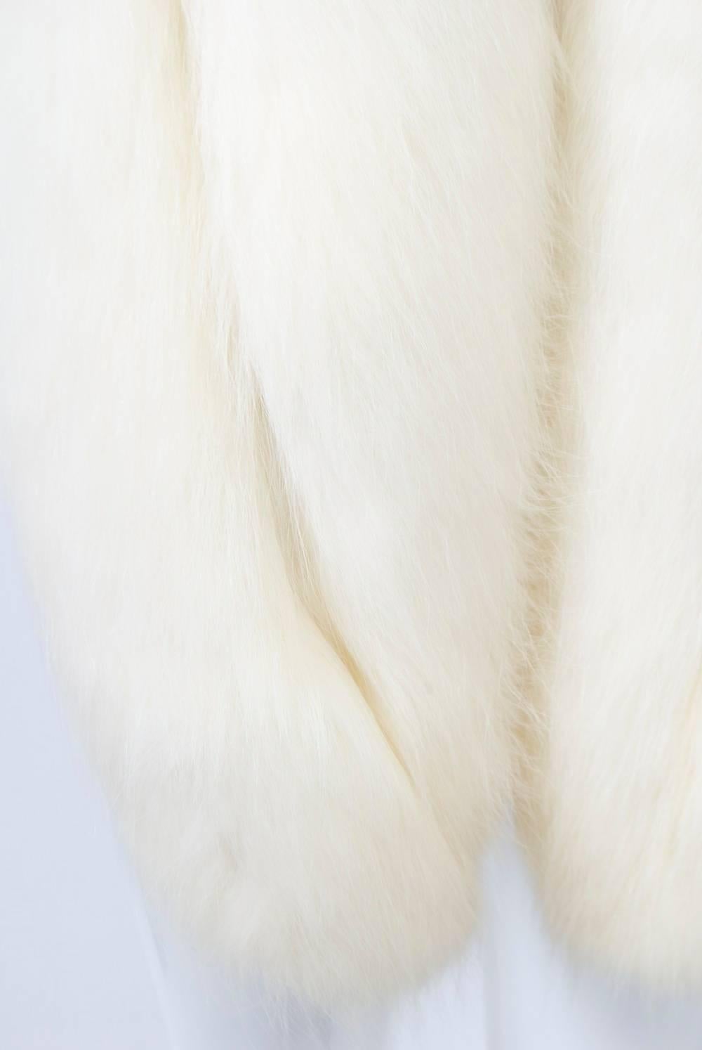 Glamorous white fox stole, double skin deep and long, curved to round points at ends. Lined in white satin with interior pockets. Fur is dense and lush.