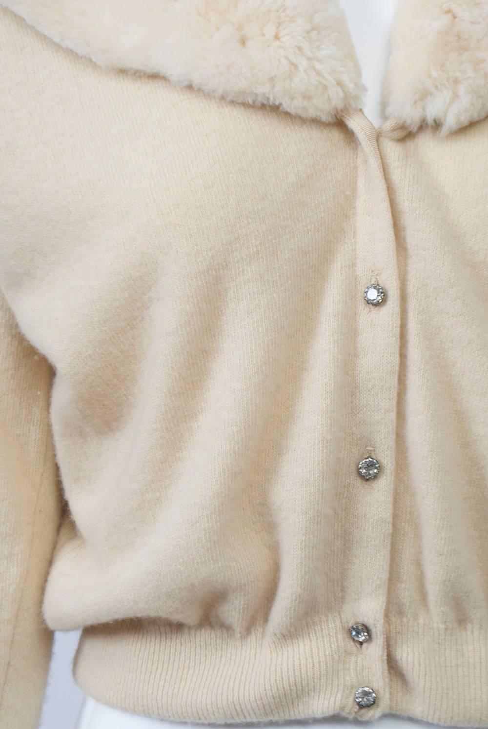 Beige cashmere cardigan featuring a sailor-style collar in matching sheared beaver and rhinestone buttons down the front and at the wrists. Matching chiffon lining. Approximate size S-M.