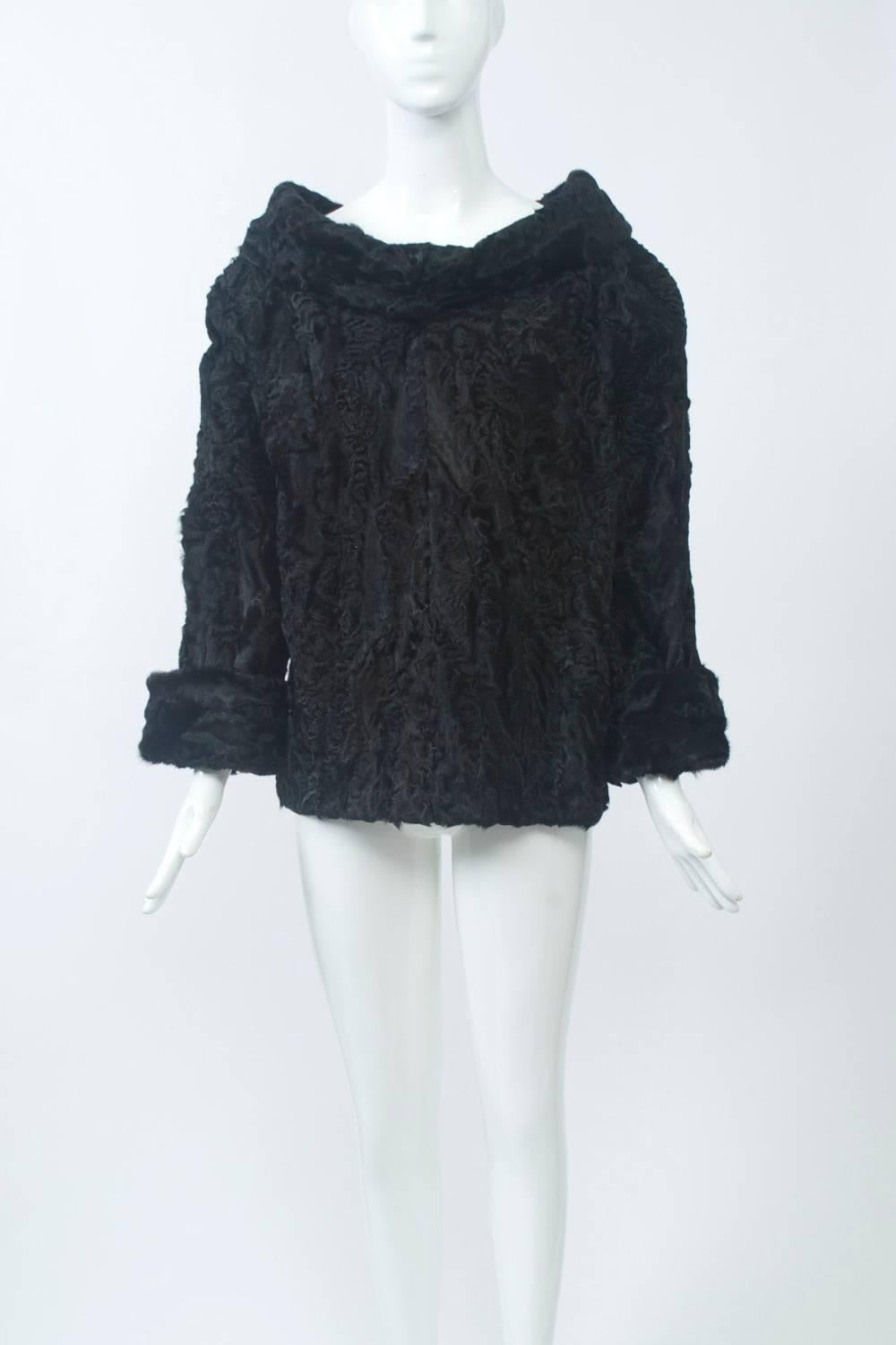 Black broadtail, custom-made tunic featuring a wide cowl collar and turned back cuffs. Slips over the head. A truly unique piece to pair with anything from jeans to a long skirt or more formal pants. Approximate size Small.