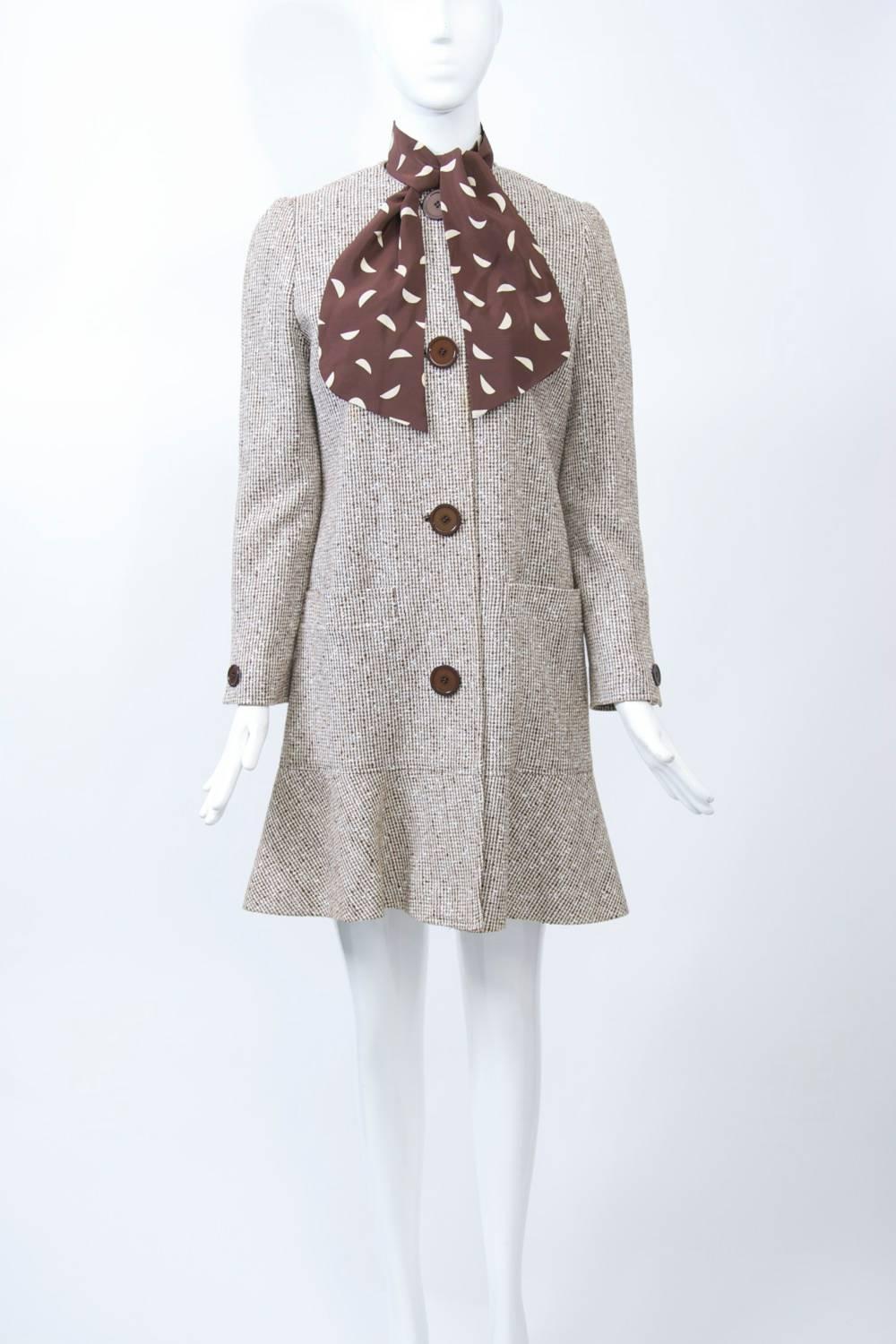 Coat and dress ensemble by David Hayes, a Los Angeles designer known for his timeless ensembles and dresses and who counted among his famous clients Nancy Reagan. The coat is fashioned of a brown tweed in a linen or cotton blend and features a deep
