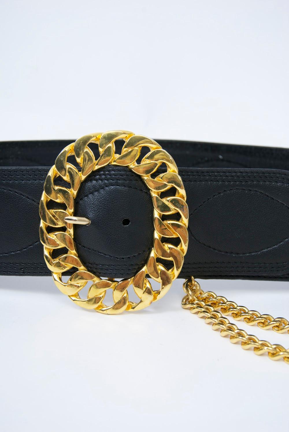 Jean L'Insolite black leather quilted belt with gold metal oval link buckle and double gold chain swag suspending a coin. Approximate waist size 29-31