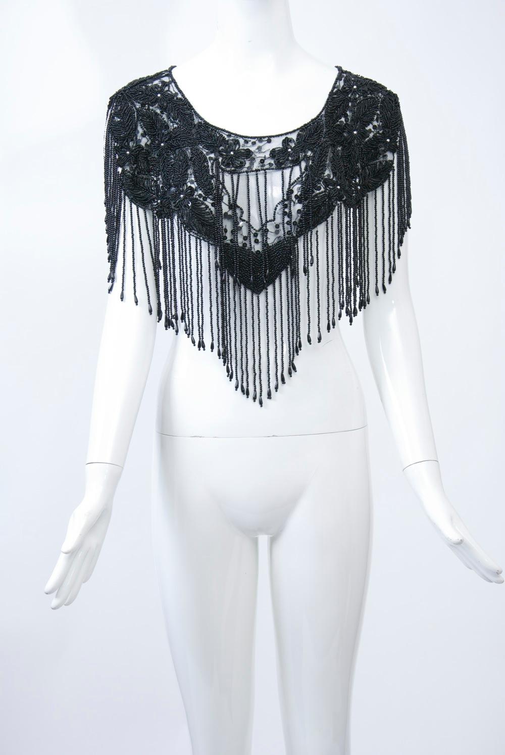 Black capelet of floral pattern beading on a net ground featuring a long beaded fringe coming to a point front and back. Slips easily over the head. Perfect dressy cover-up for long spaghetti-strap dress or camisole. Provenance: singer Edie Gorme.