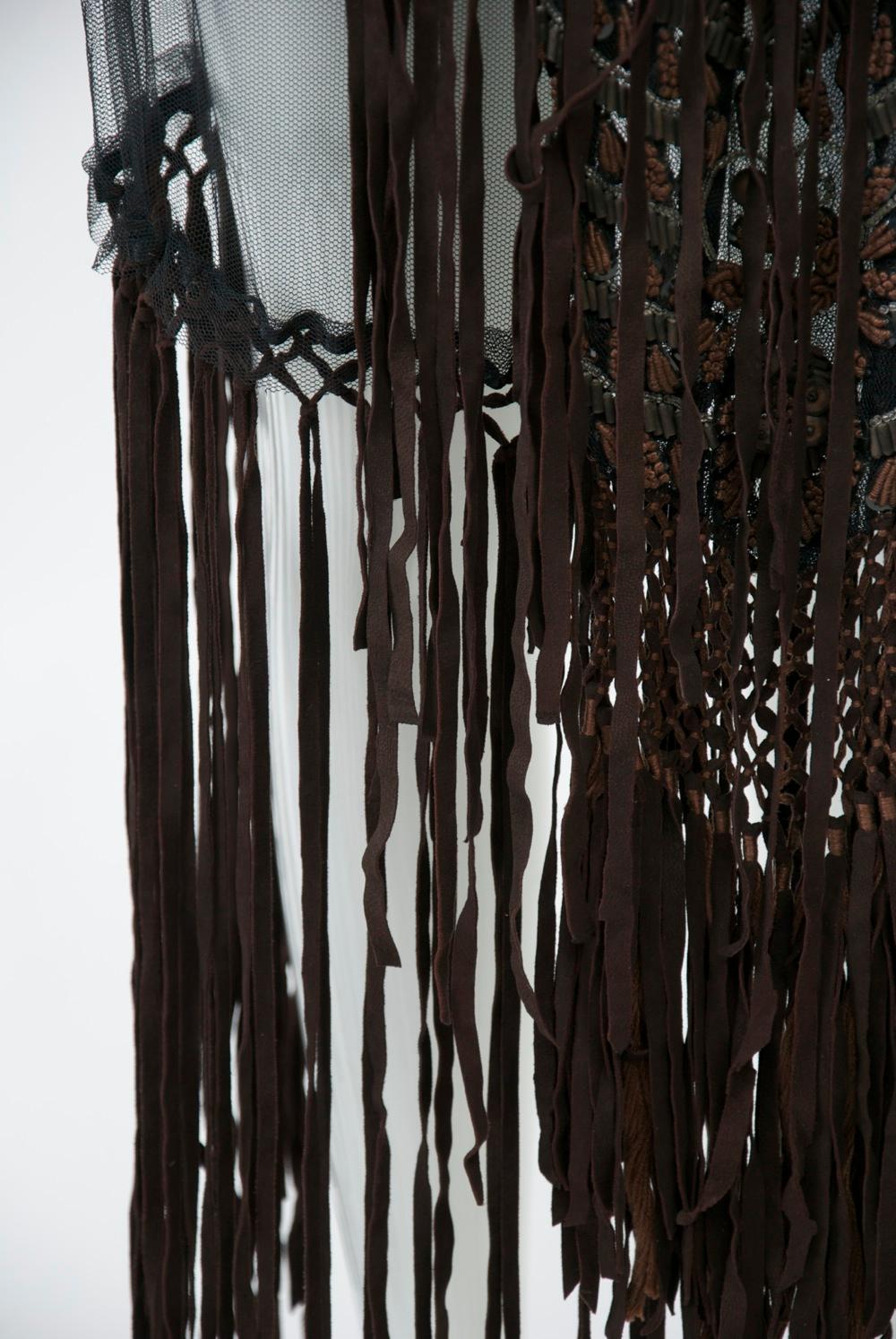 A vintage Fendi piece, c.1970s, composed of an interesting mix of materials. The overskirt features black net suspended from a denim hip band; below the netting is brown suede fringe that descends to the ankles. The centerpiece is a matching fringed