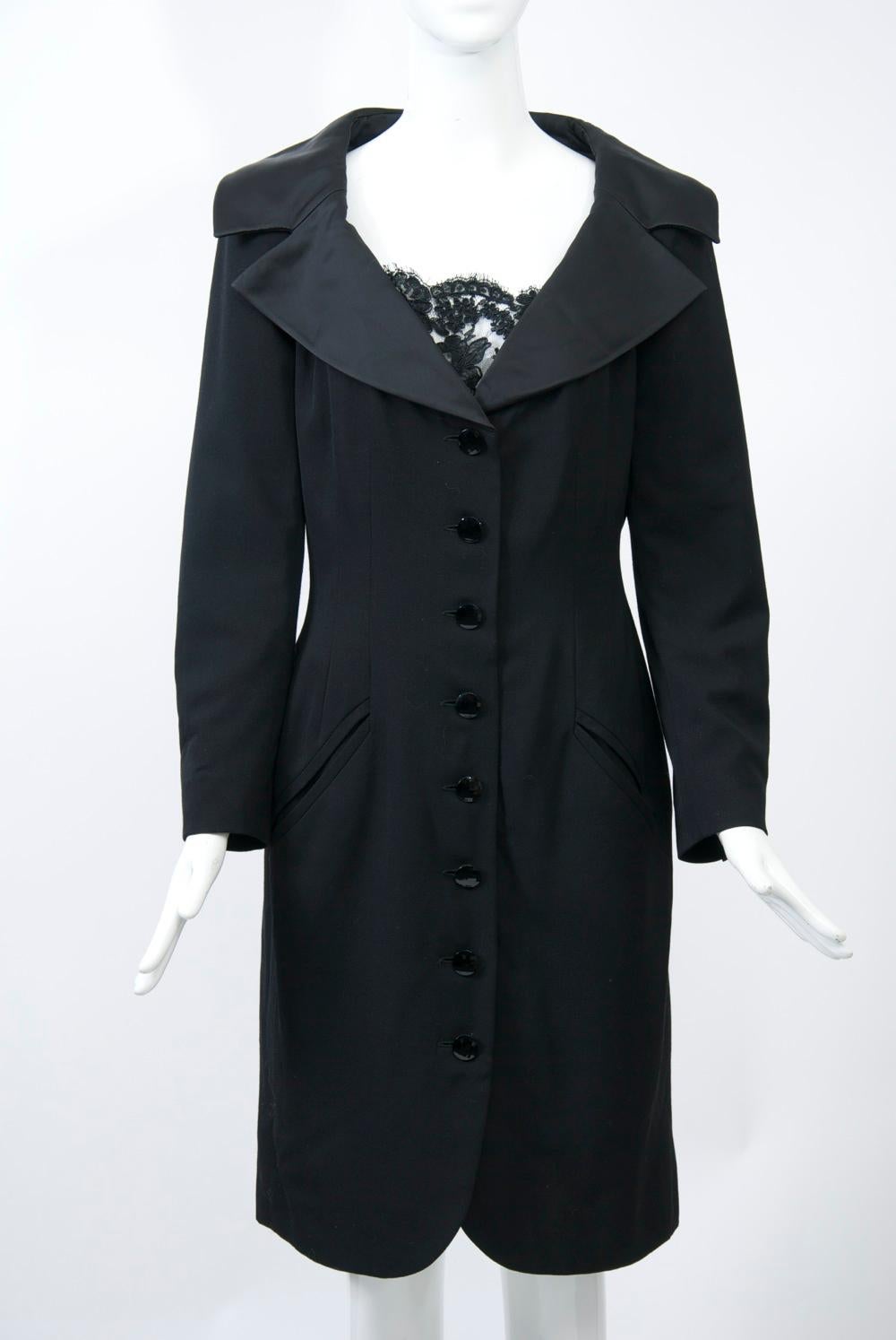 Jean Louis Scherrer classic black coatdress with tuxedo detailing in its taffeta spread collar and four-button wrists. The body is shaped with front and back darts and features a button-down front terminating in curves at the hem, as well as
