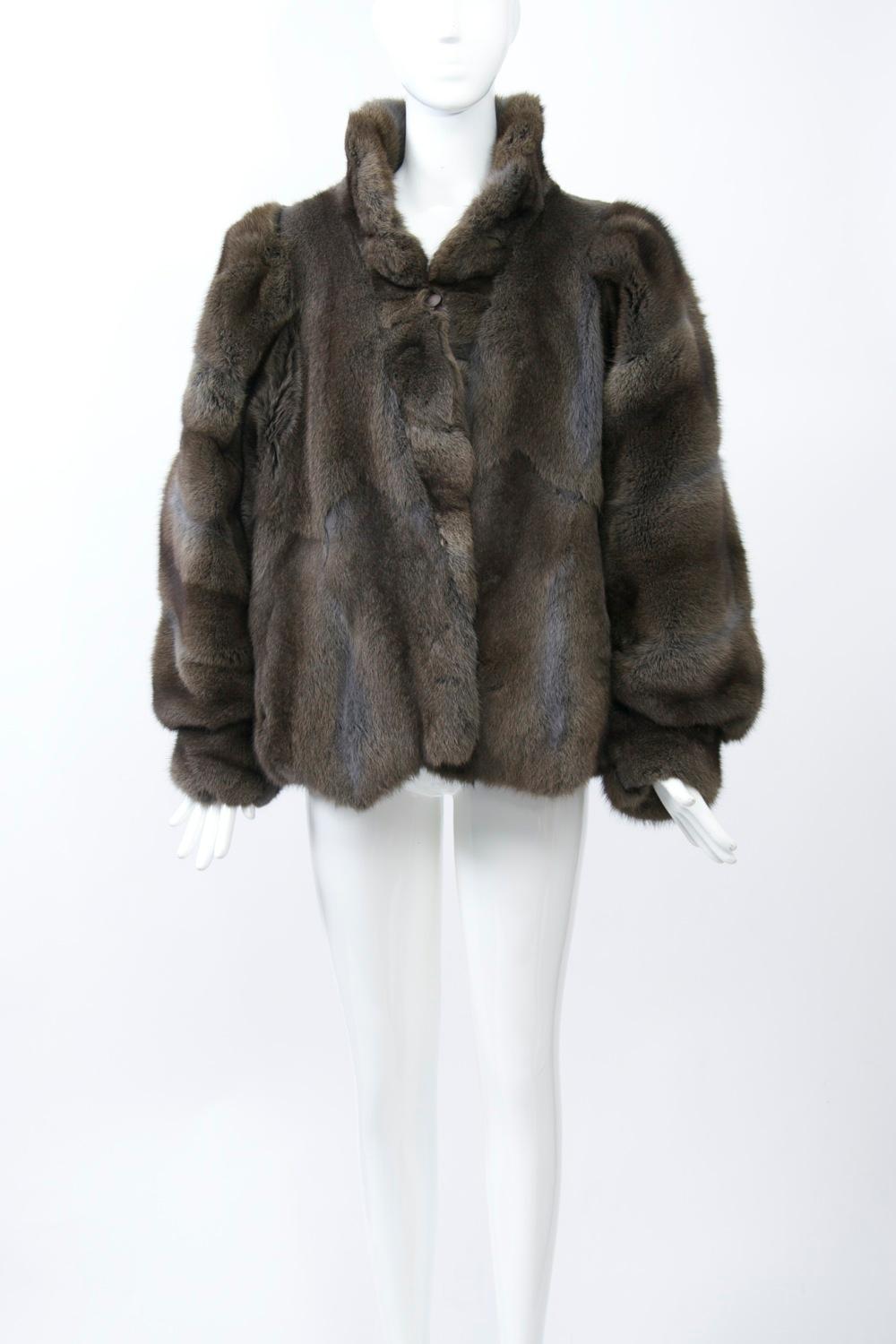1980s oversized cut in this hip-length sheared fur jacket, possibly opossum or raccoon. The fur is lush and cut in flat, broad pieces throughout the body with their zigzag edging also finishing the hem. The full sleeves are worked with horizontal