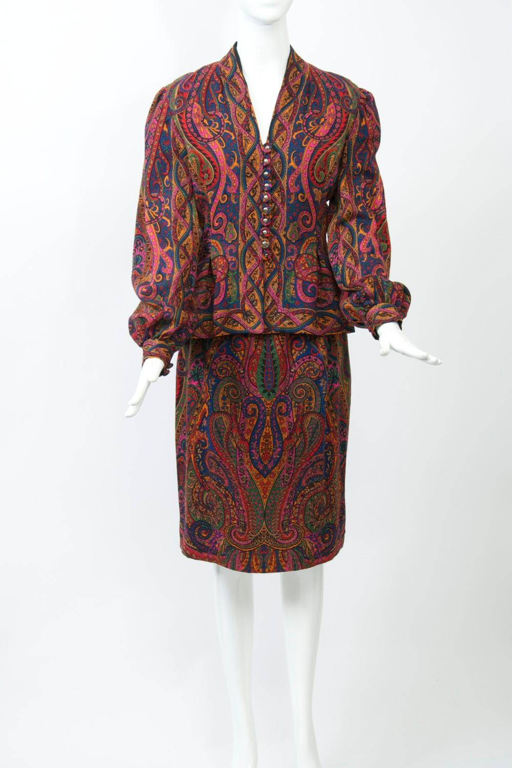 From one of the masters of American fashion, Featured is a two-piece dress or suit in a sophisticated palette paisley wool challis, from one of the masters of American fashion. The V-neck jacket has a darted bodice stitched to the waist, which then