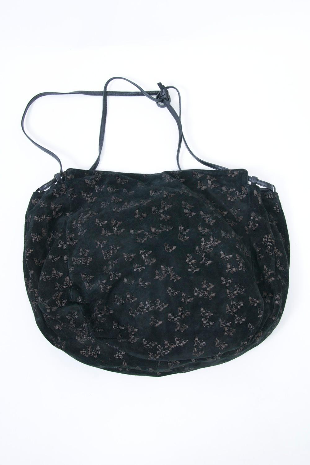 Roomy pouch shoulder bag by Bottega Veneta in black suede with a light butterfly motif throughout. A black leather cord looks through the top to provide double straps that are adjustable. Snap closure. Interior has a zippered side compartment.