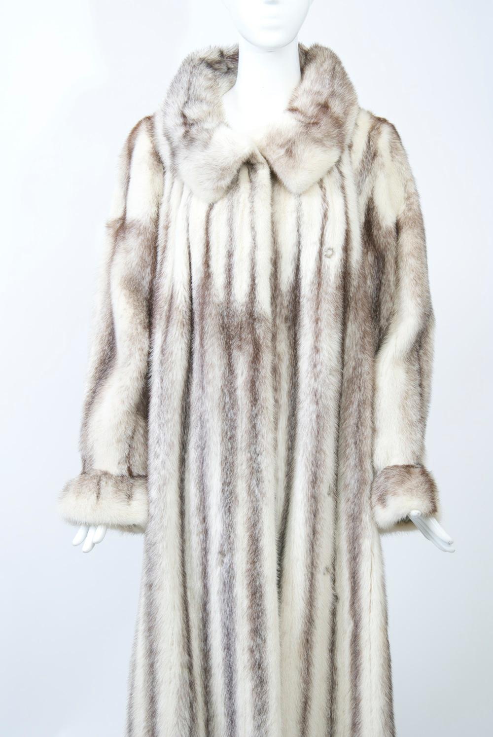 Brown-tipped white mink lends pizazz to this full-length coat, which also exhibits plenty of style. The slightly shaped body flares a bit and features a convertible collar that can be worn multiple ways. A ruffle at the wrist adds interest to the