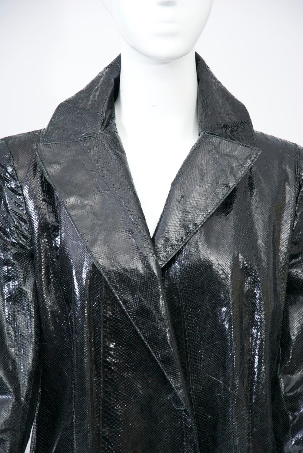 Genny snakeskin coat features a single-button closure and large pockets with flaps. Deep vent in back. Square shoulders. Lining is rayon/acetate. Approximate size M.