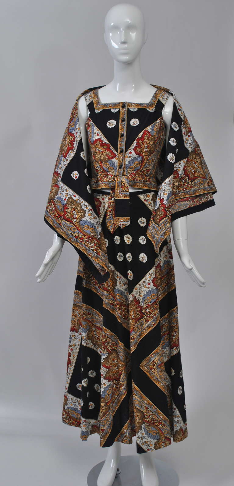 Wonderful 1970s look in an ensemble by Eleanor Brenner composed of a long A-line skirt, vest-style top and large square shawl, all in a polished cotton scarf print on a black ground. The pattern is worked diagonally to form Vs front and back. The