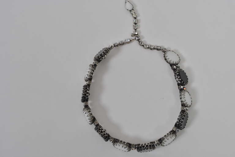 Unique piece designed by Christian Dior for Kramer, composed of alternating black and white glass disks set in a sturdy silver metal mount interspersed with rhinestones. Adjustable rhinestone chain closure terminating in marquise white stone.