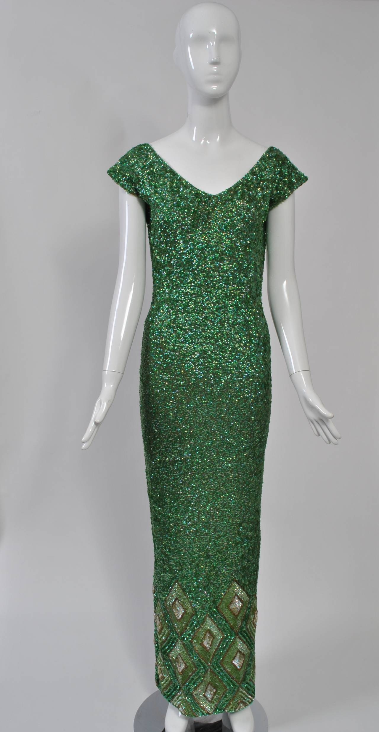 This sequined gown is a stunning example of the embellished knits popular during the 1950s and '60s, most of which were made in Hong Kong. Featuring a body hugging silhouette, cap sleeves and a rounded v neckline in front and deep v in back, the